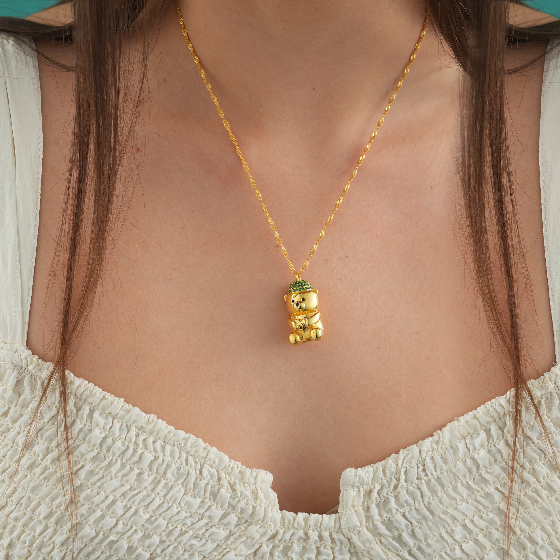 Bearista Sterling Silver Birthstone Bear Charm worn on a gold necklace, showcasing the intricate design and vibrant colors.