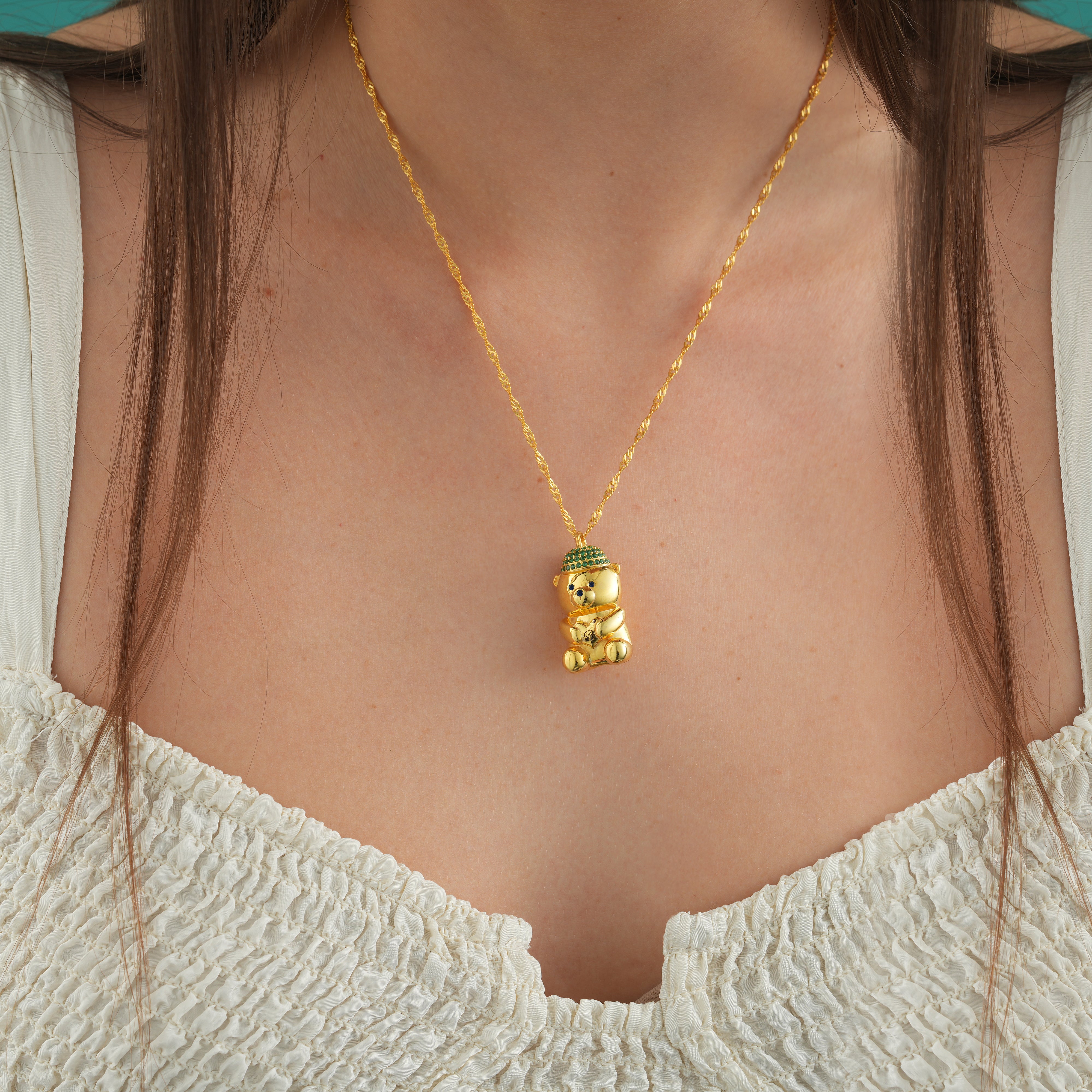 Bearista Sterling Silver Birthstone Bear Charm worn on a gold necklace, showcasing the intricate design and vibrant colors.