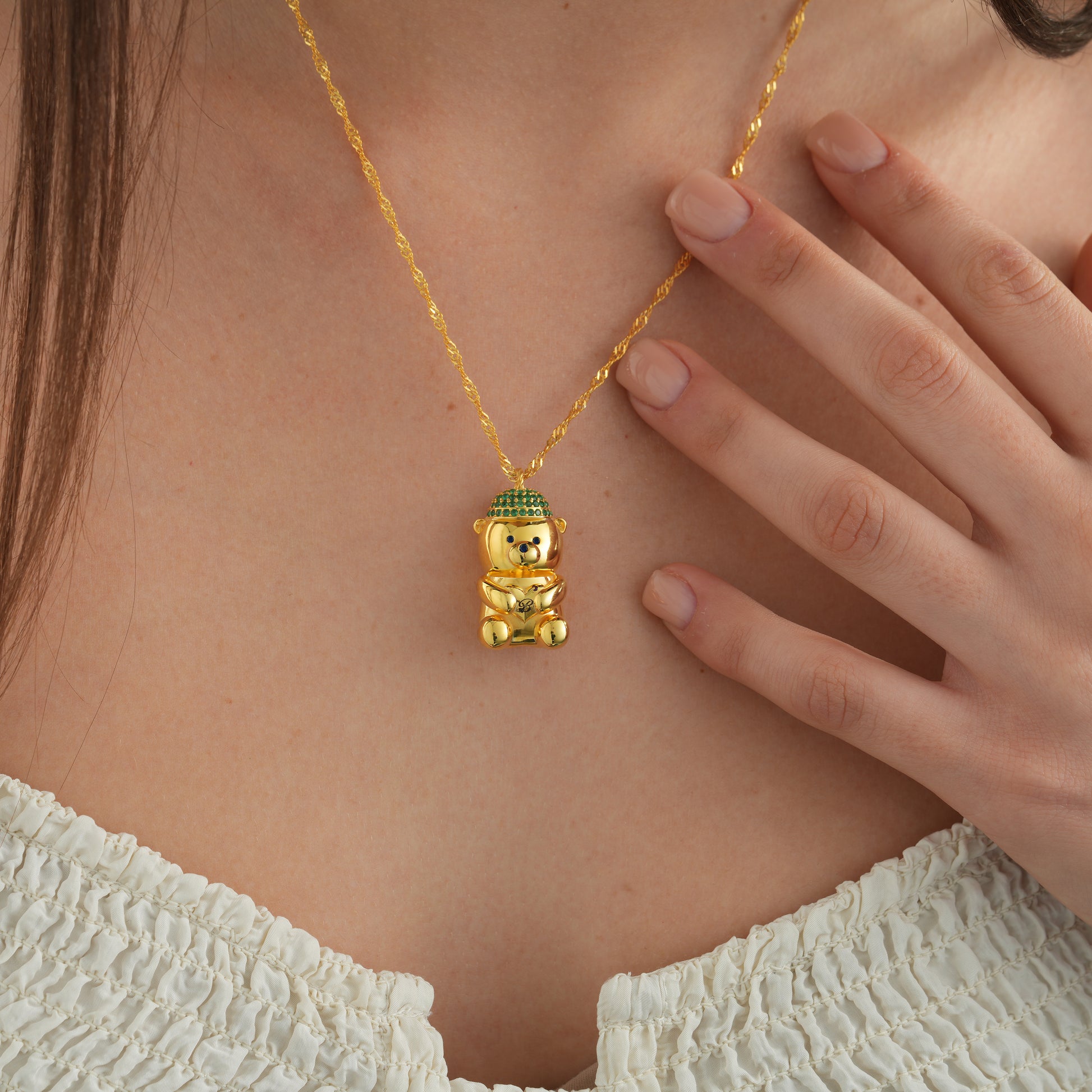 Woman wearing a Bearista Sterling Silver Birthstone Bear Charm necklace featuring a gold bear pendant.