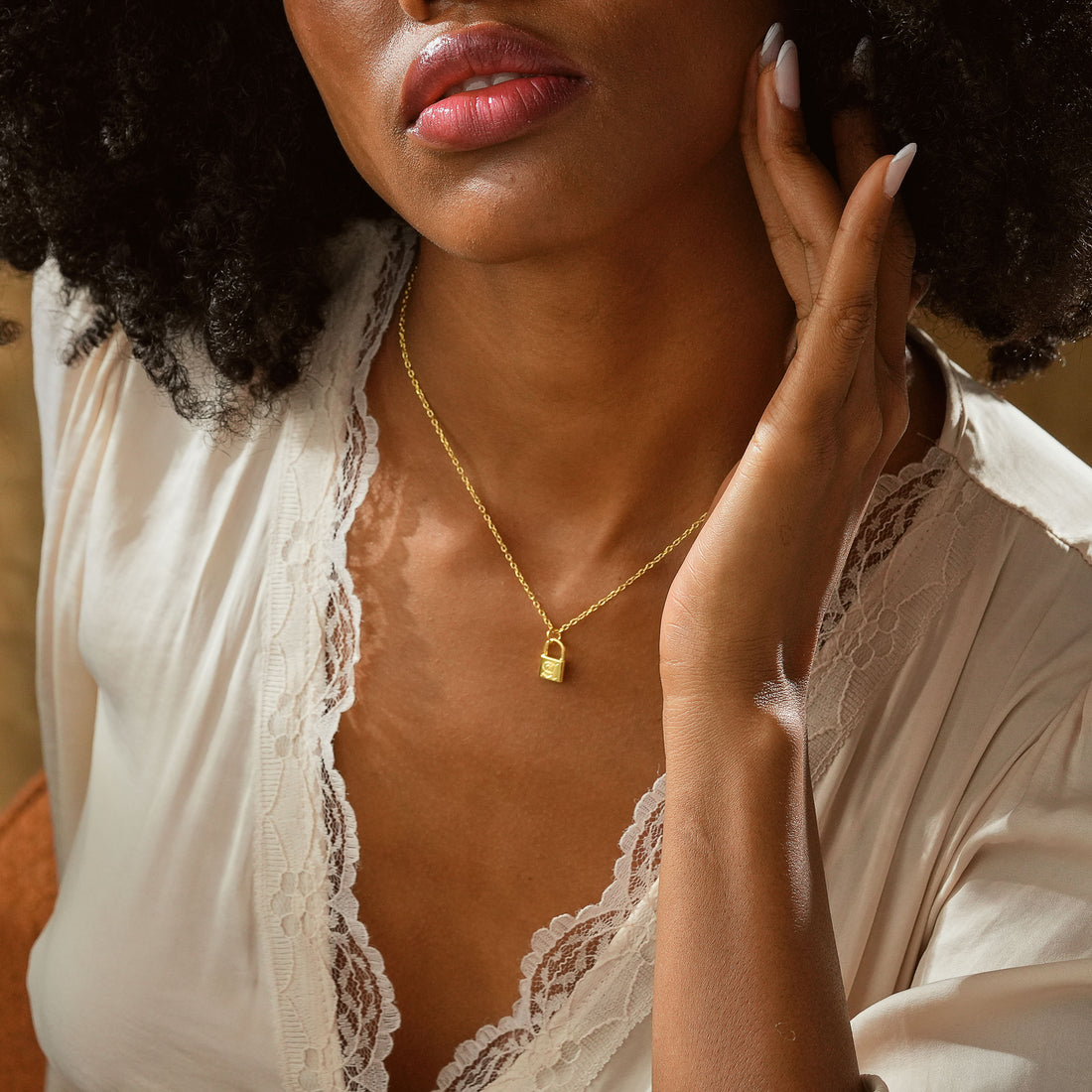 Close-up of a woman wearing a Personalized Initial Padlock Necklace in gold, showcasing its elegant design.