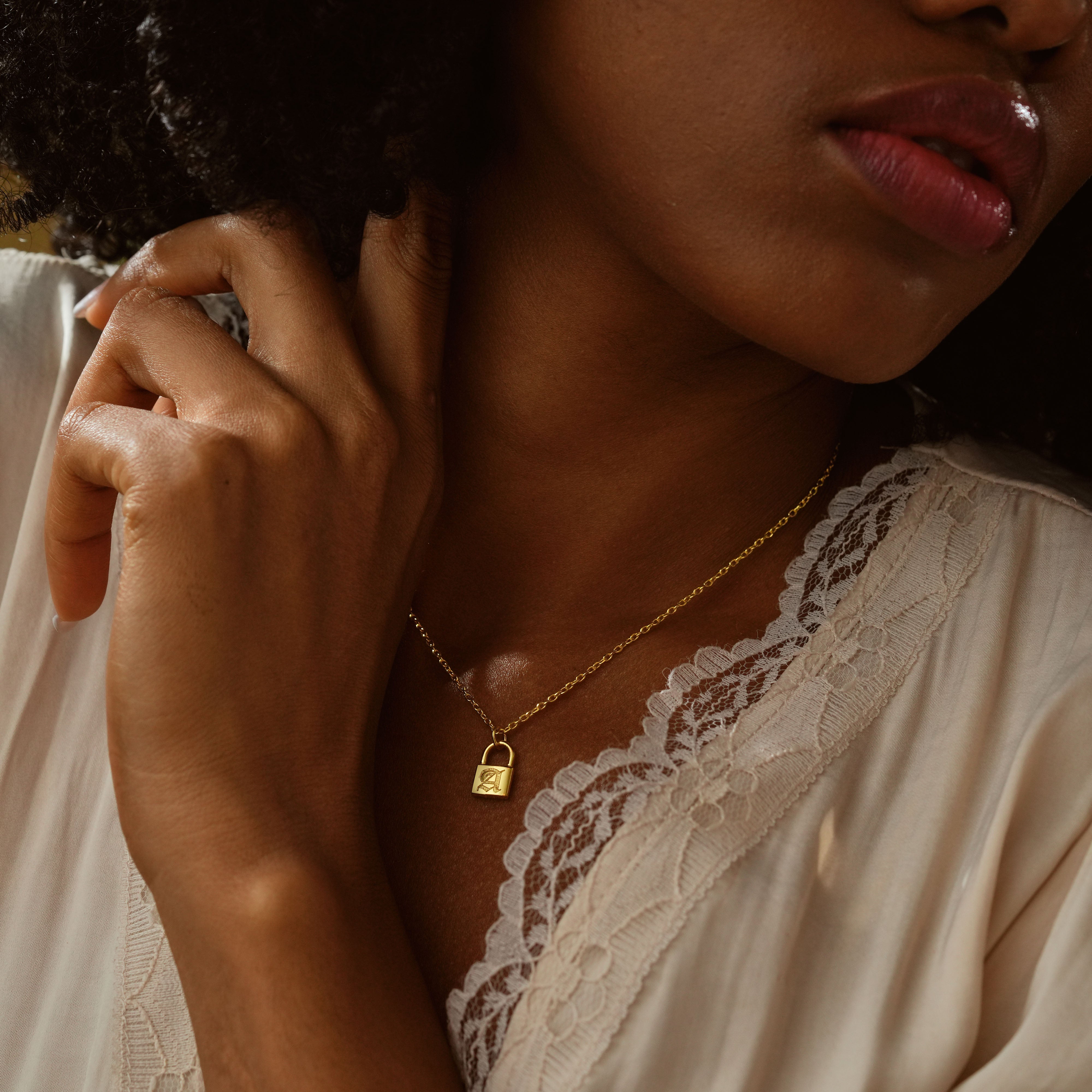 Close-up of woman wearing a Personalized Initial Padlock Necklace in gold on a delicate chain.