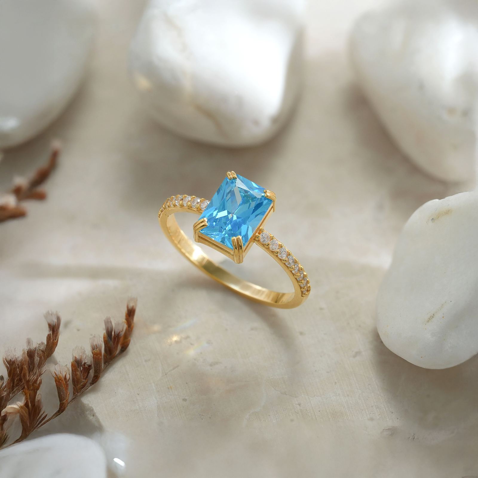 Rectangle Statement Birthstone Ring featuring a blue gemstone set in gold against white stones.