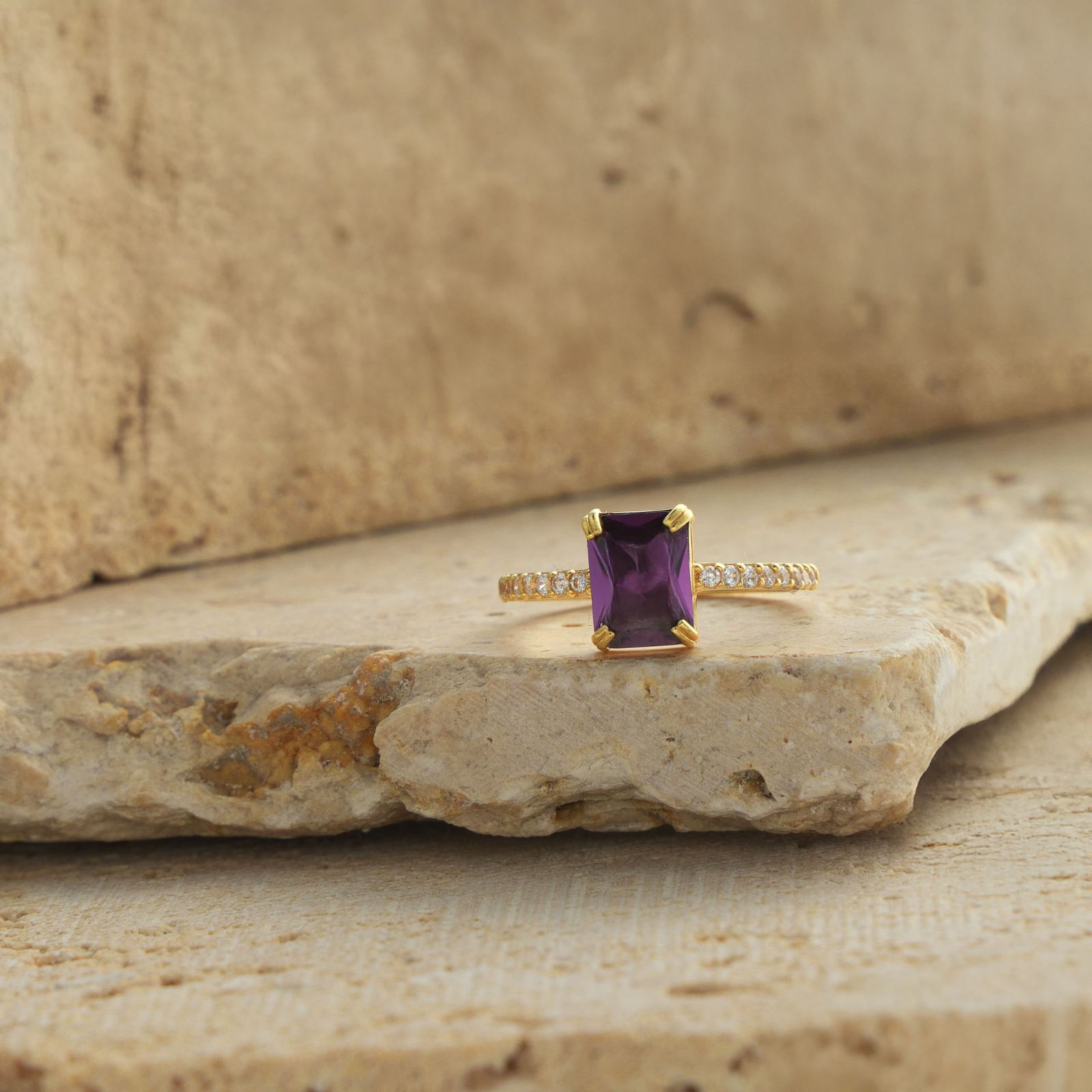 Rectangle Statement Birthstone Ring featuring a purple gemstone set in gold vermeil on a stone surface.
