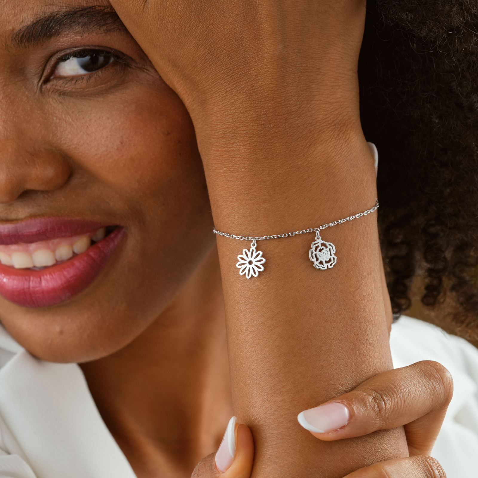Custom Birth Flower Bracelet displayed on a woman's wrist, featuring flower charms and a stylish silver chain.