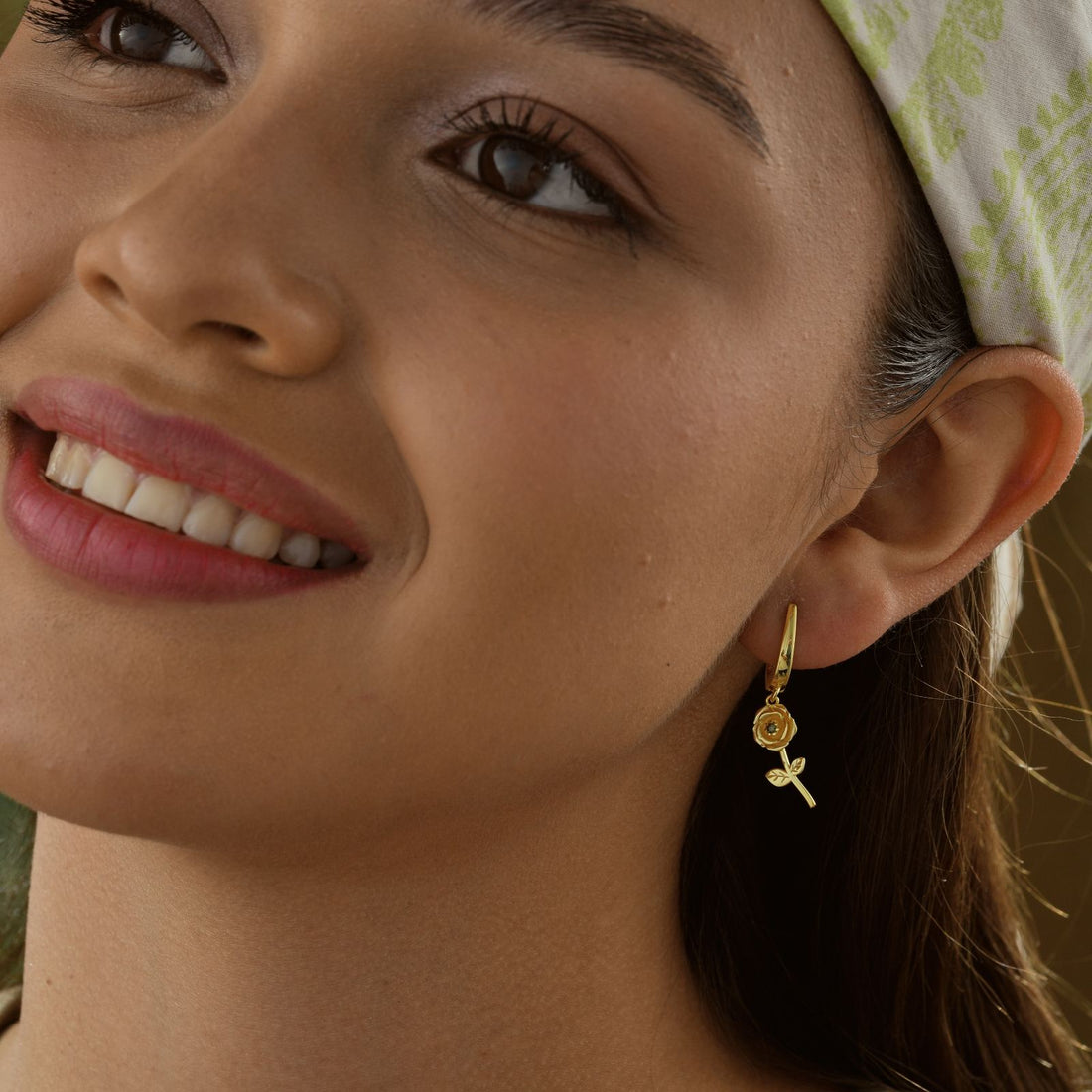 Close-up of a woman wearing Birth Flower Hoop Earring in gold vermeil, showcasing its intricate floral design.