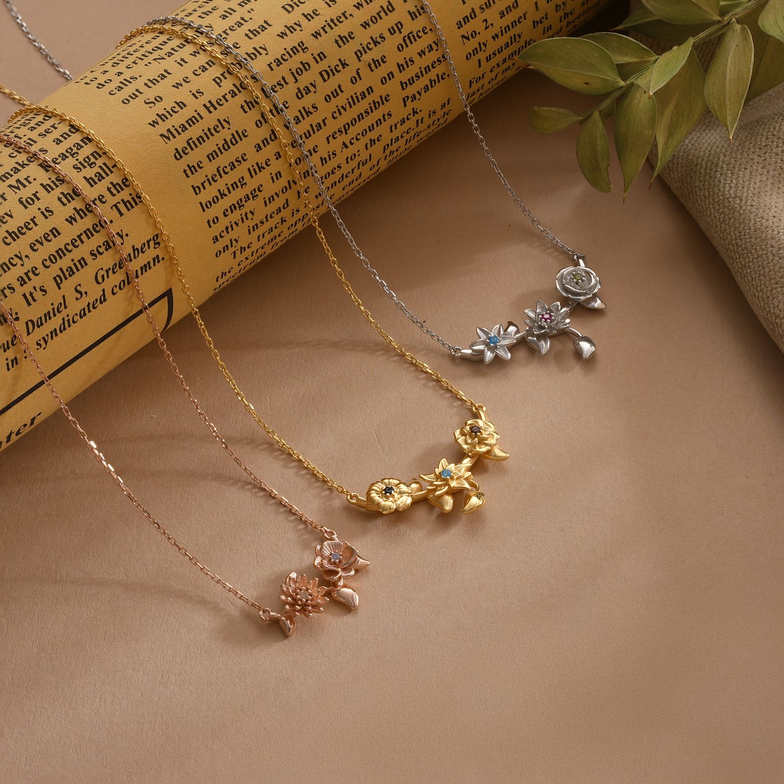 Custom 3D Birth Flower Necklace in gold, silver, and rose gold finishes displayed against a vintage paper backdrop.