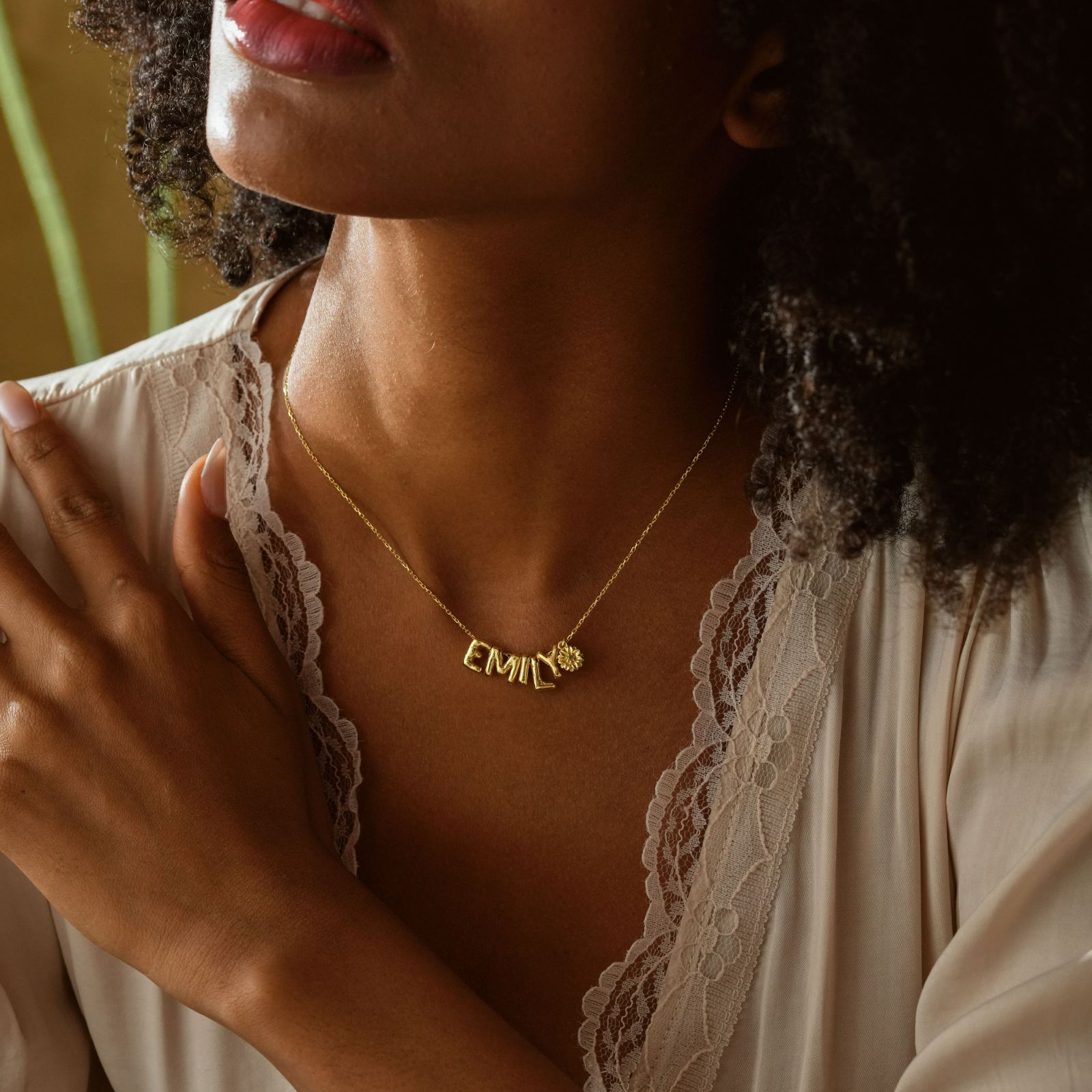 3D Bubble Letter Necklace With Birth Flower worn by a woman, featuring the name 'EMILY' in gold.