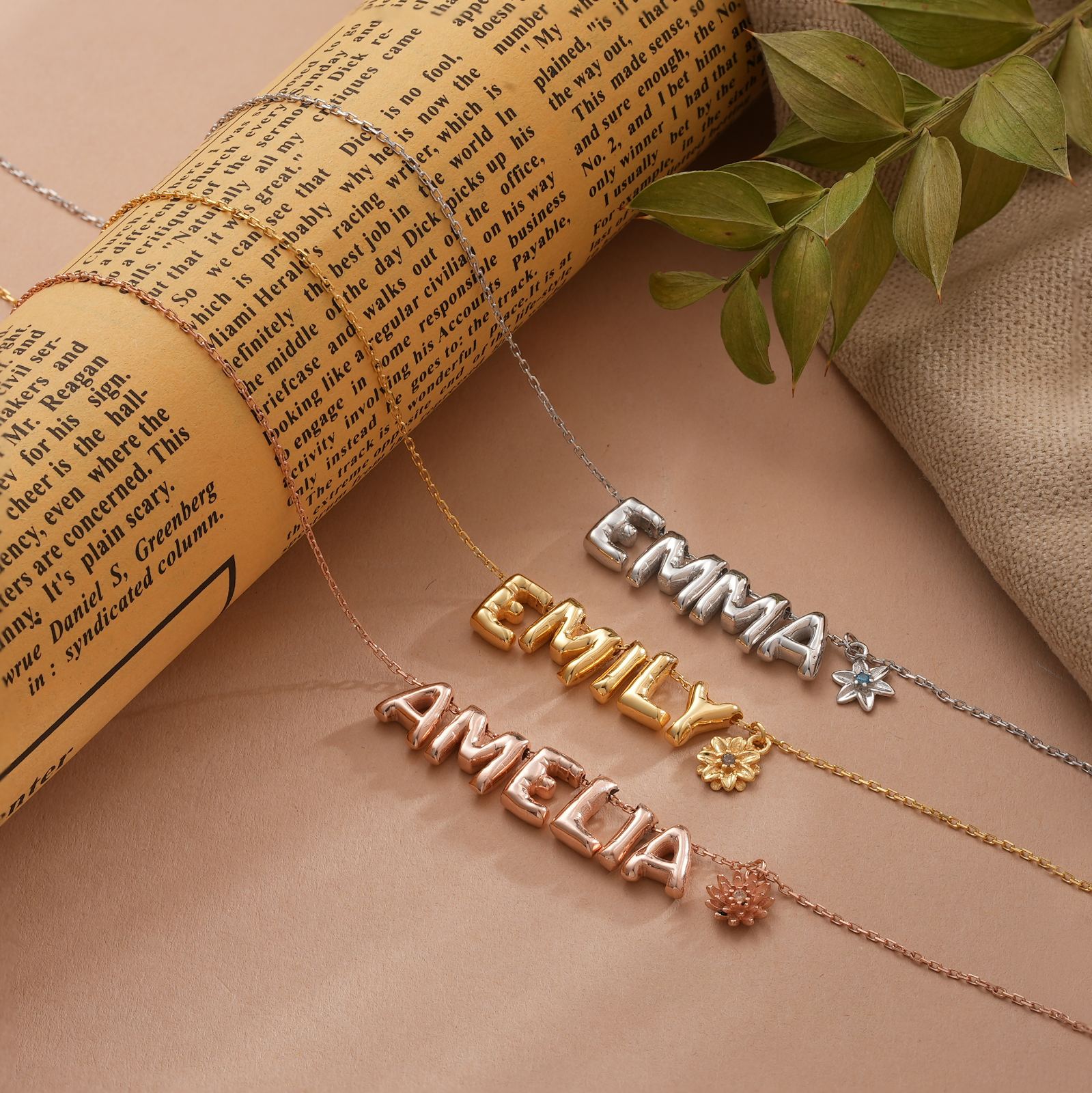 3D Bubble Letter necklaces with birth flowers, personalized names Emma, Emily, and Amelia displayed on a vintage paper.