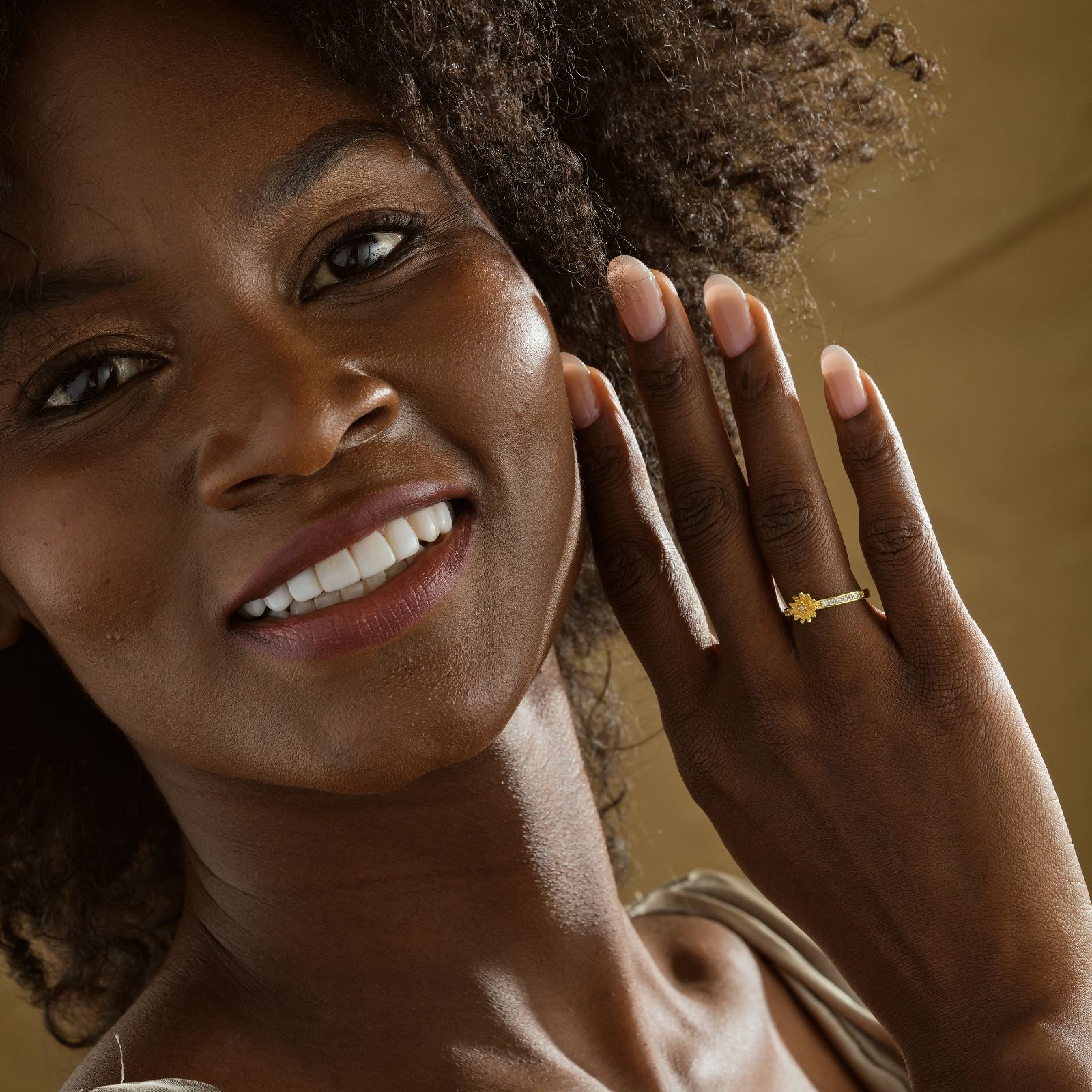 Smiling woman wearing a Personalized Birth Flower Ring in Silver Cubic Zirconia on her hand.