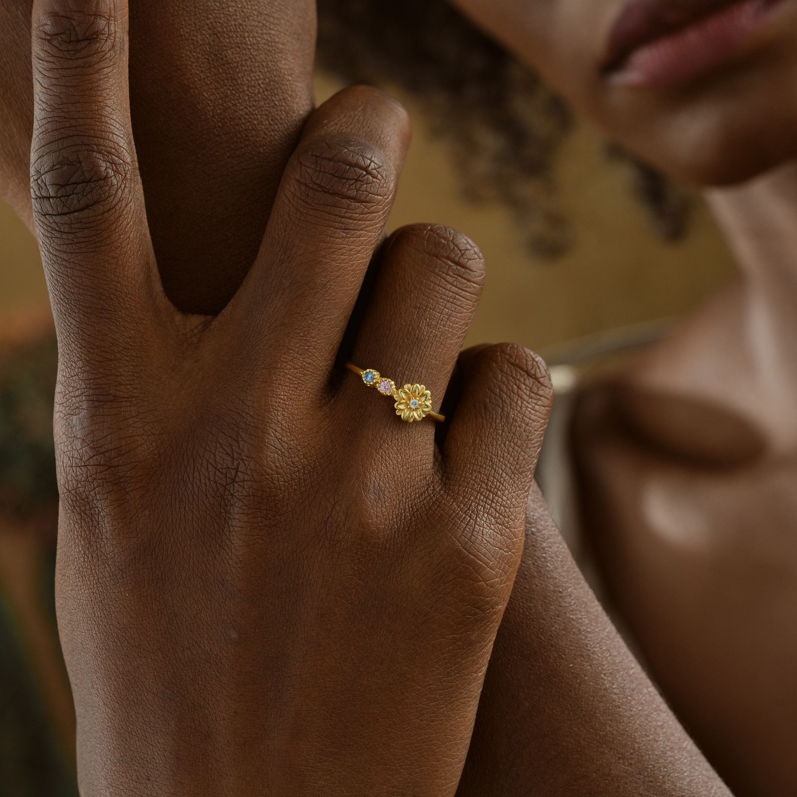 Custom Birth Flower Ring with Birthstone worn on a hand, featuring a floral design and colorful gemstones.