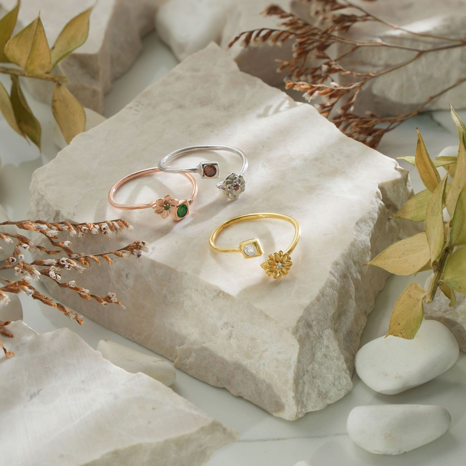 Adjustable Open Ring - Custom Birth Flower Ring displayed on stone with dried leaves and pebbles.