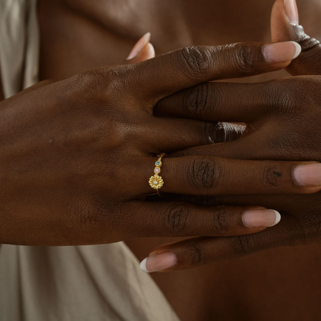Custom Birth Flower Ring with Birthstone worn on hand, featuring gold vermeil and colorful gemstones.