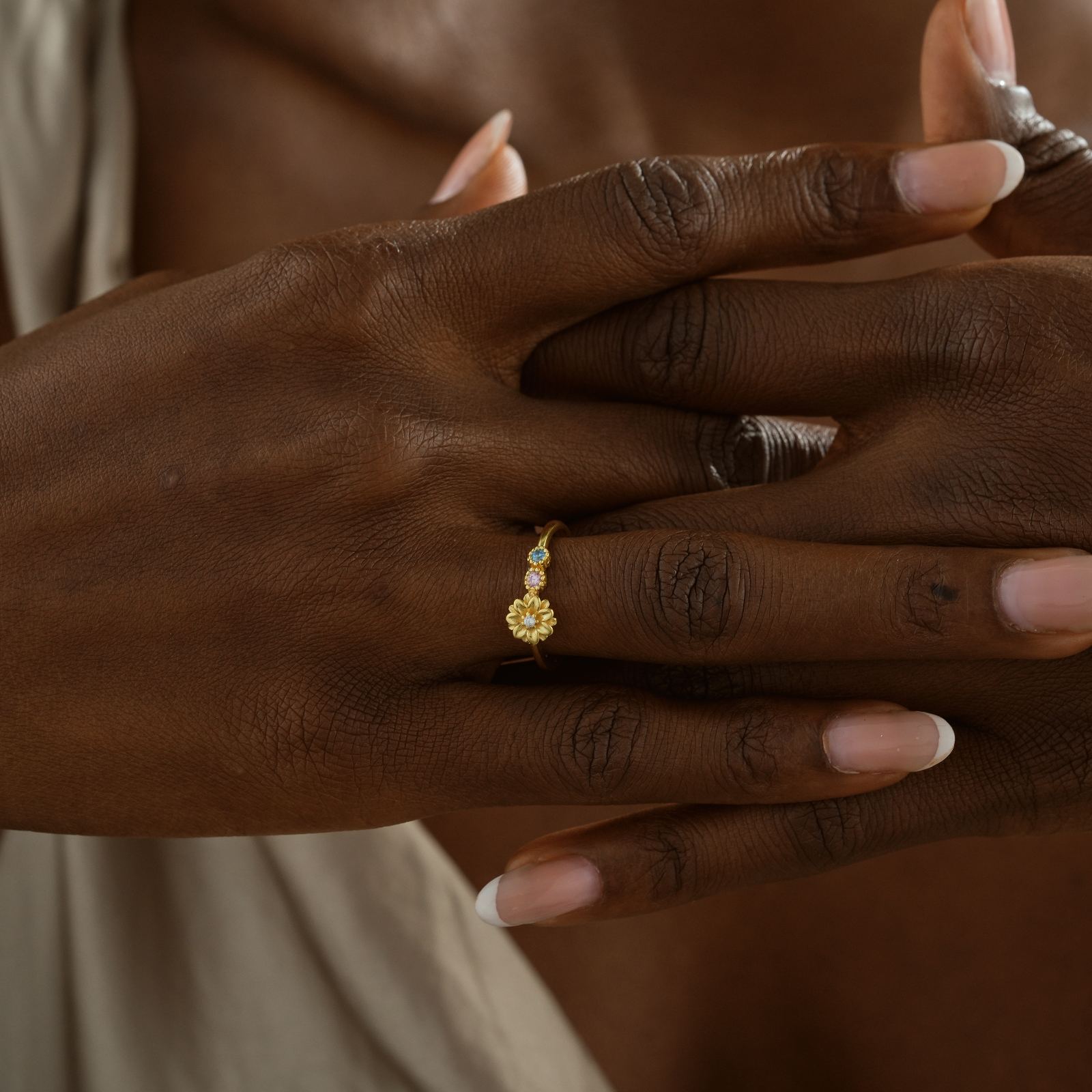 Custom Birth Flower Ring with Birthstone worn on hand, featuring gold vermeil and colorful gemstones.