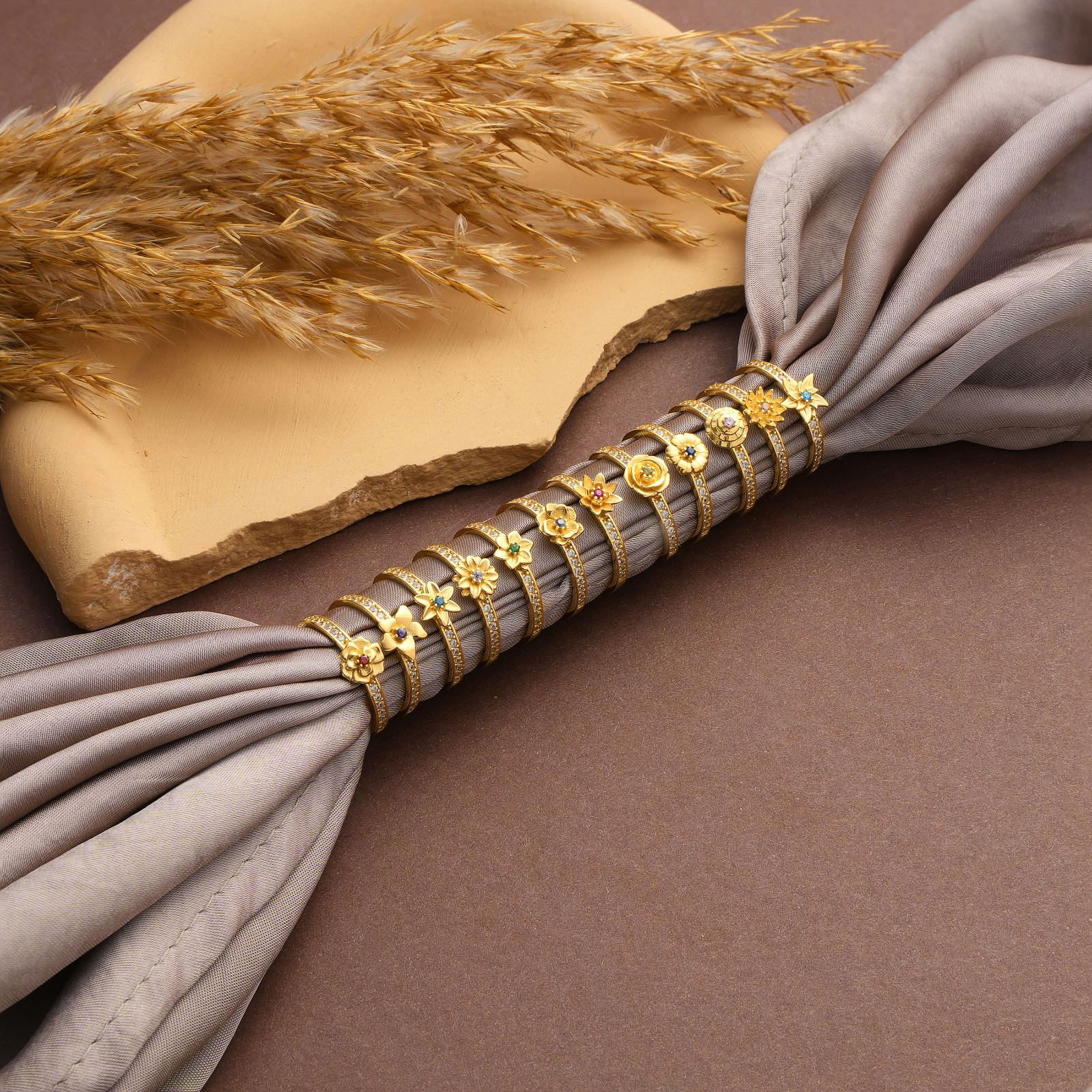 Personalized Birth Flower Ring displayed with elegant fabric, featuring floral designs and gold accents.