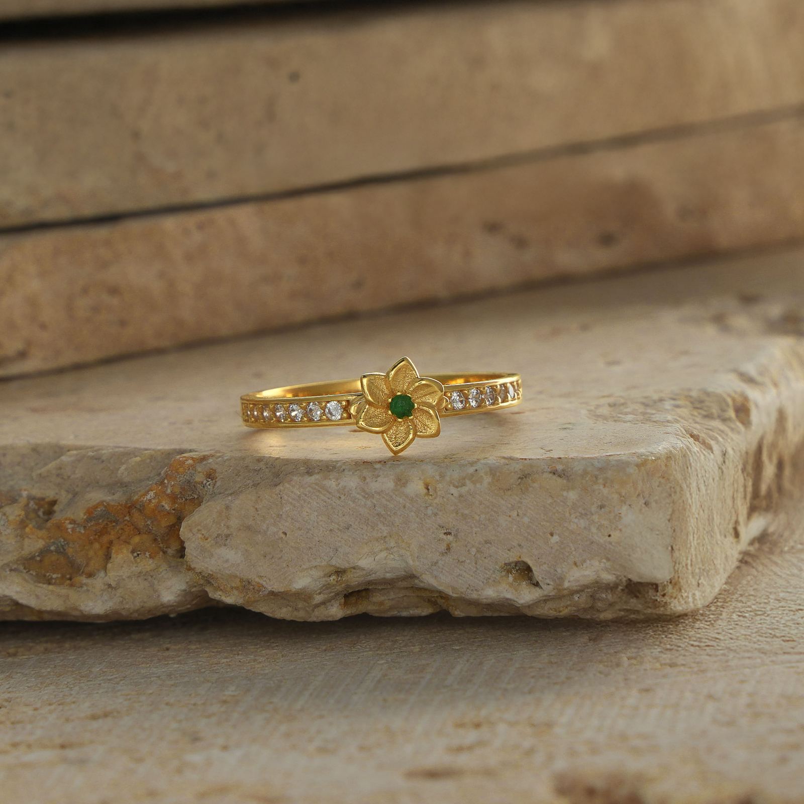 Personalized Birth Flower Ring in Silver Cubic Zirconia on a stone surface.