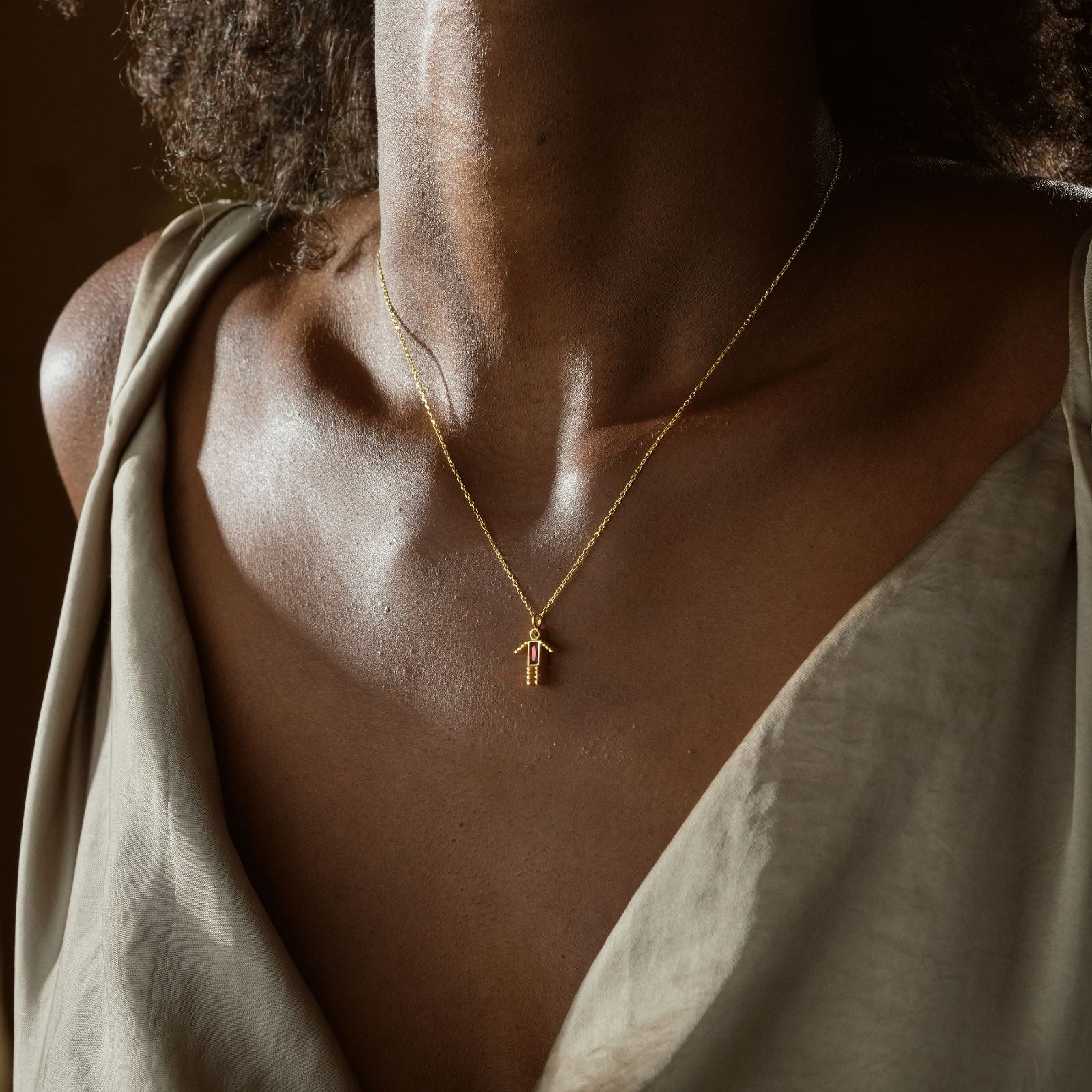 A model wearing a Dainty Boy Birthstone Charm Necklace in gold, showcasing its elegant design and charm feature.