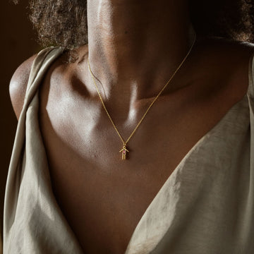 A model wearing a Dainty Boy Birthstone Charm Necklace in gold, showcasing its elegant design and charm feature.