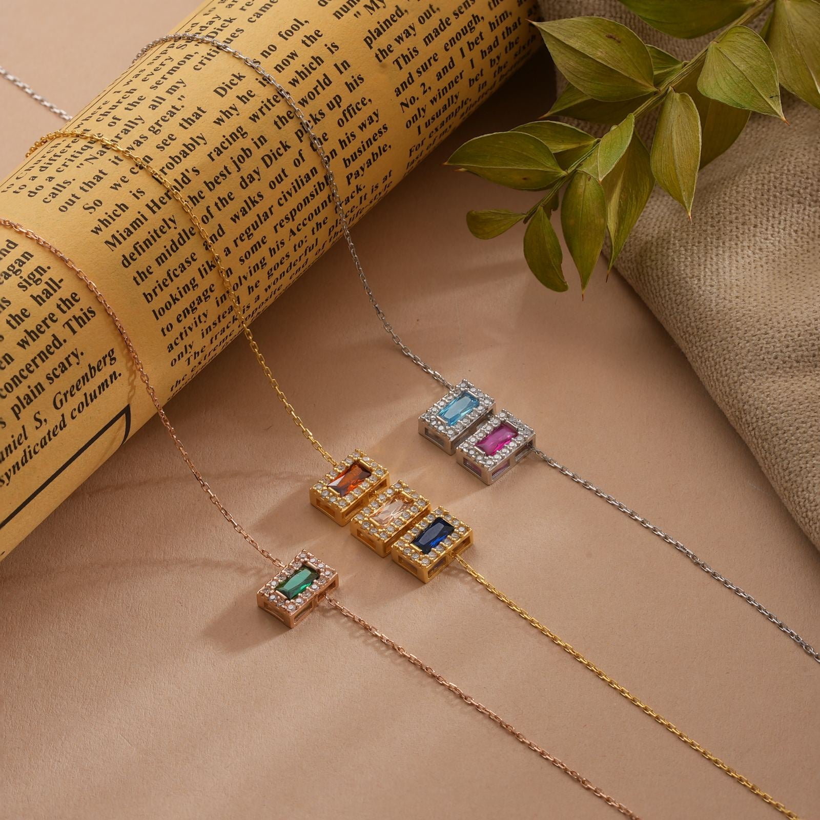Rectangle Personalized Birthstone Necklace displayed on a textured surface with vintage book and greenery.