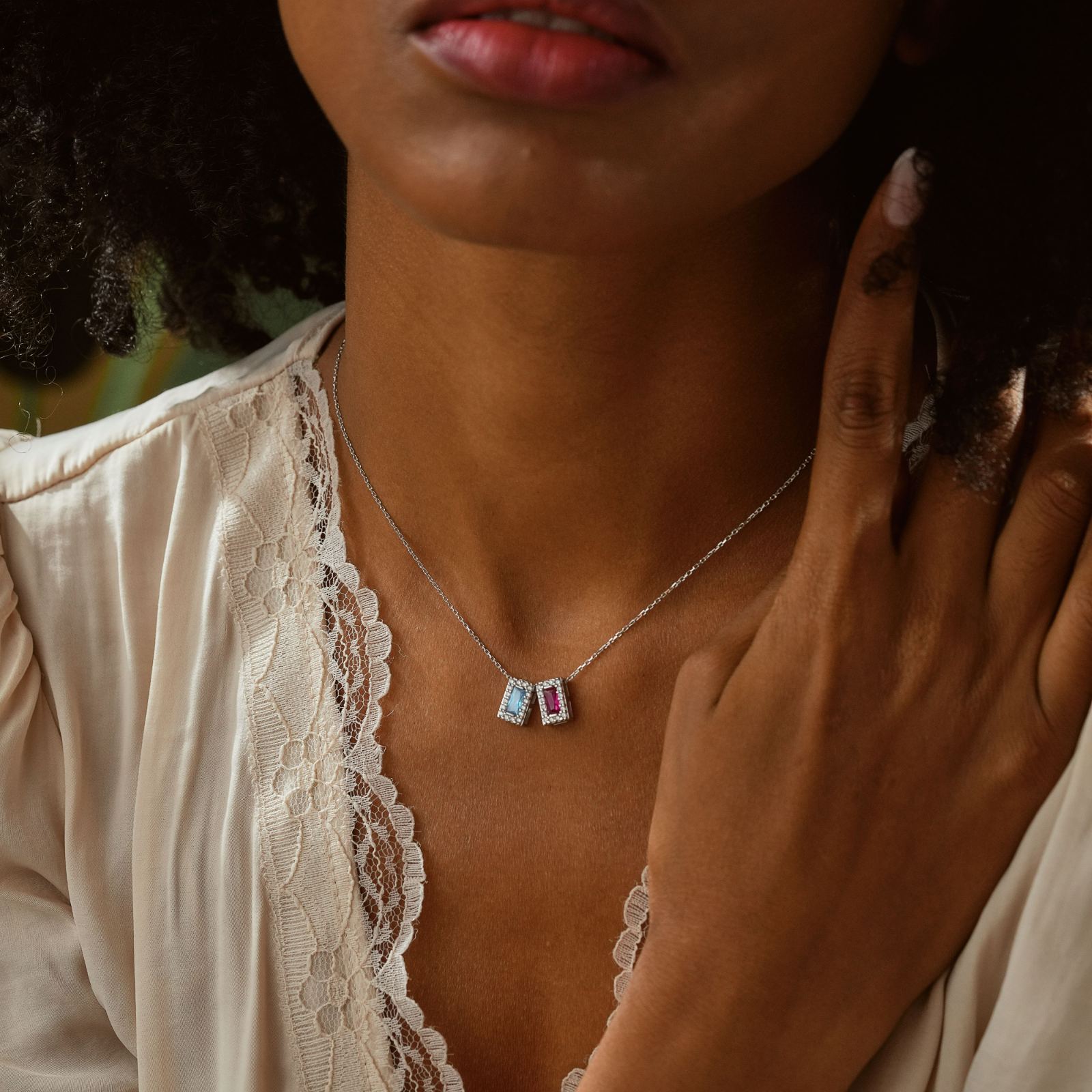 Woman wearing a Rectangle Personalized Birthstone Necklace with two colorful birthstones, showcasing elegance and style.