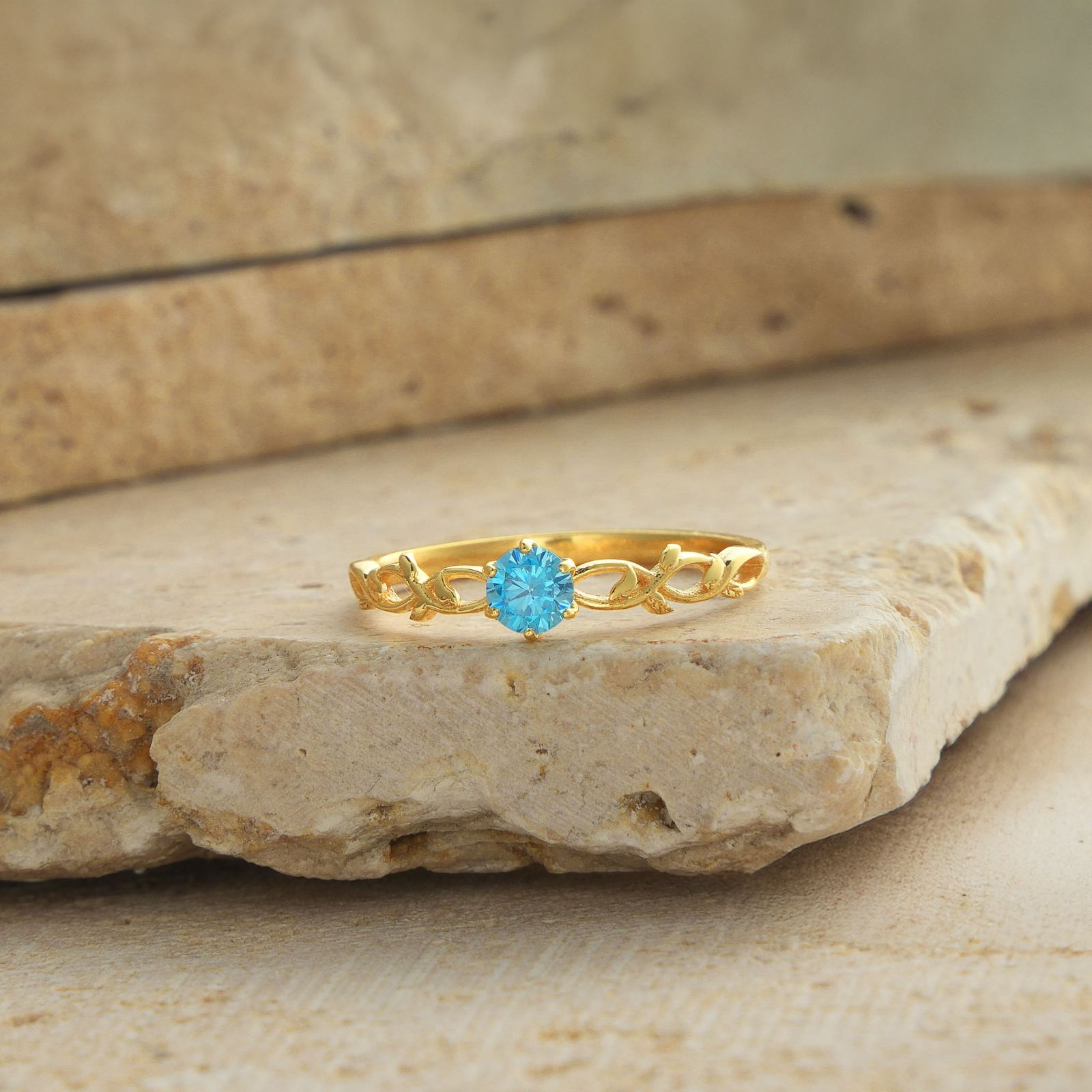 Nature-Inspired Floral Birthstone Ring featuring a blue gemstone on a golden band.