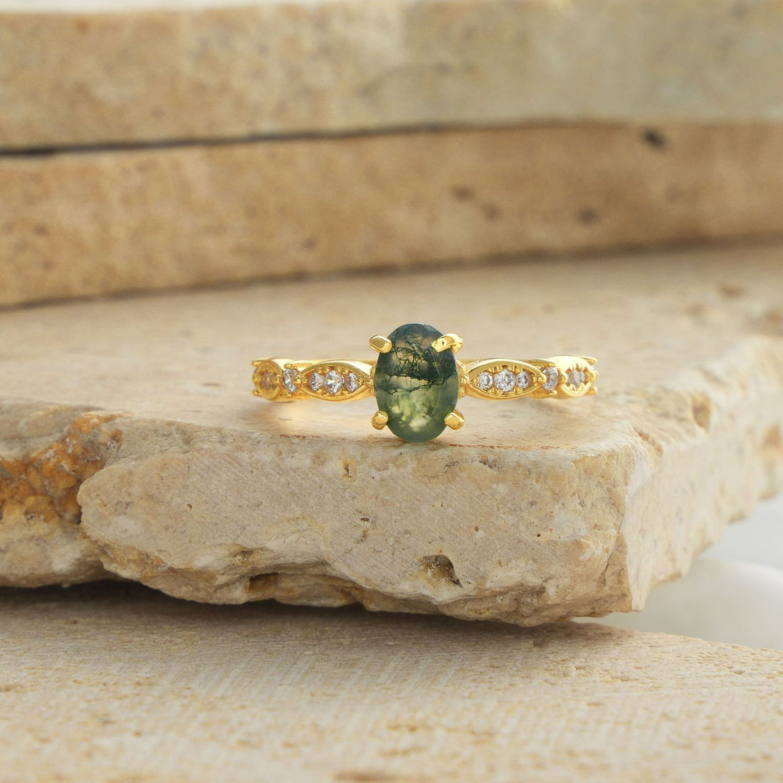Woman wearing a Custom Birthstone Ring with a green gemstone, smiling while showcasing her elegant hand.