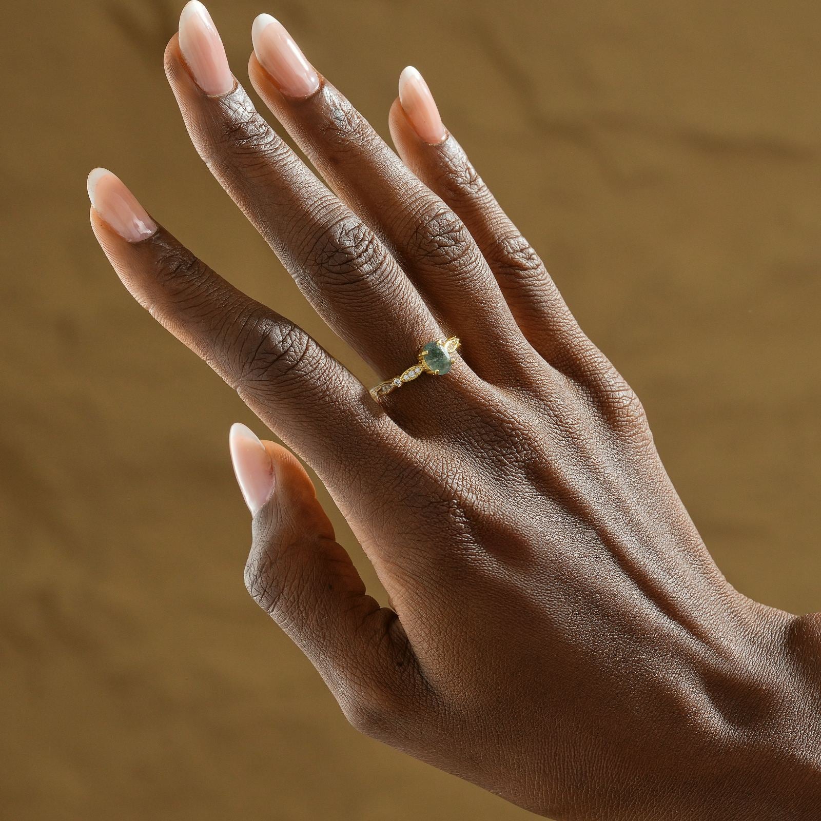 Hand wearing a custom birthstone ring in gold vermeil, showcasing a beautiful aquamarine gemstone.