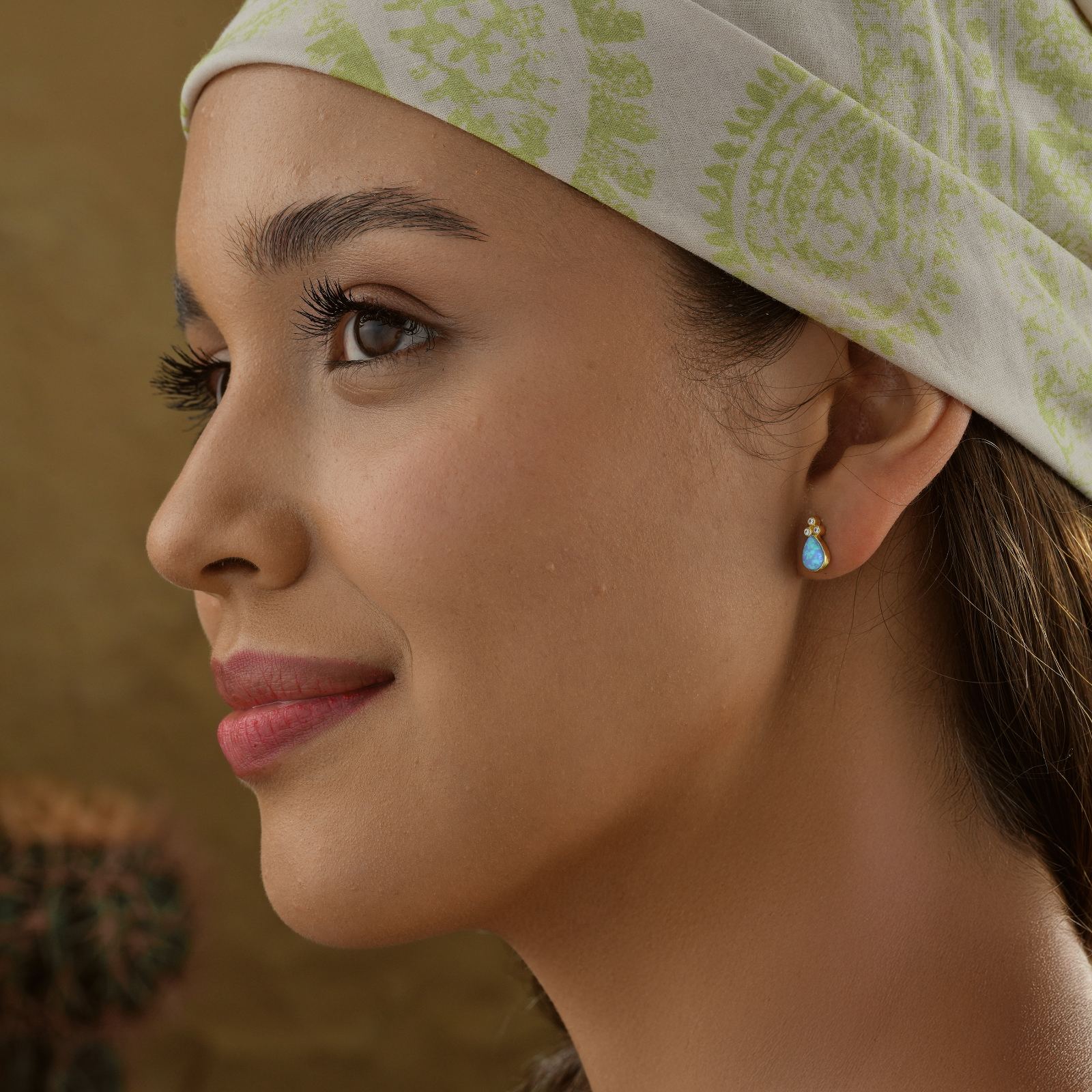 Woman wearing an Elegant Blue Opal Ring earring in 925 sterling silver, showcasing its beautiful blue hue.