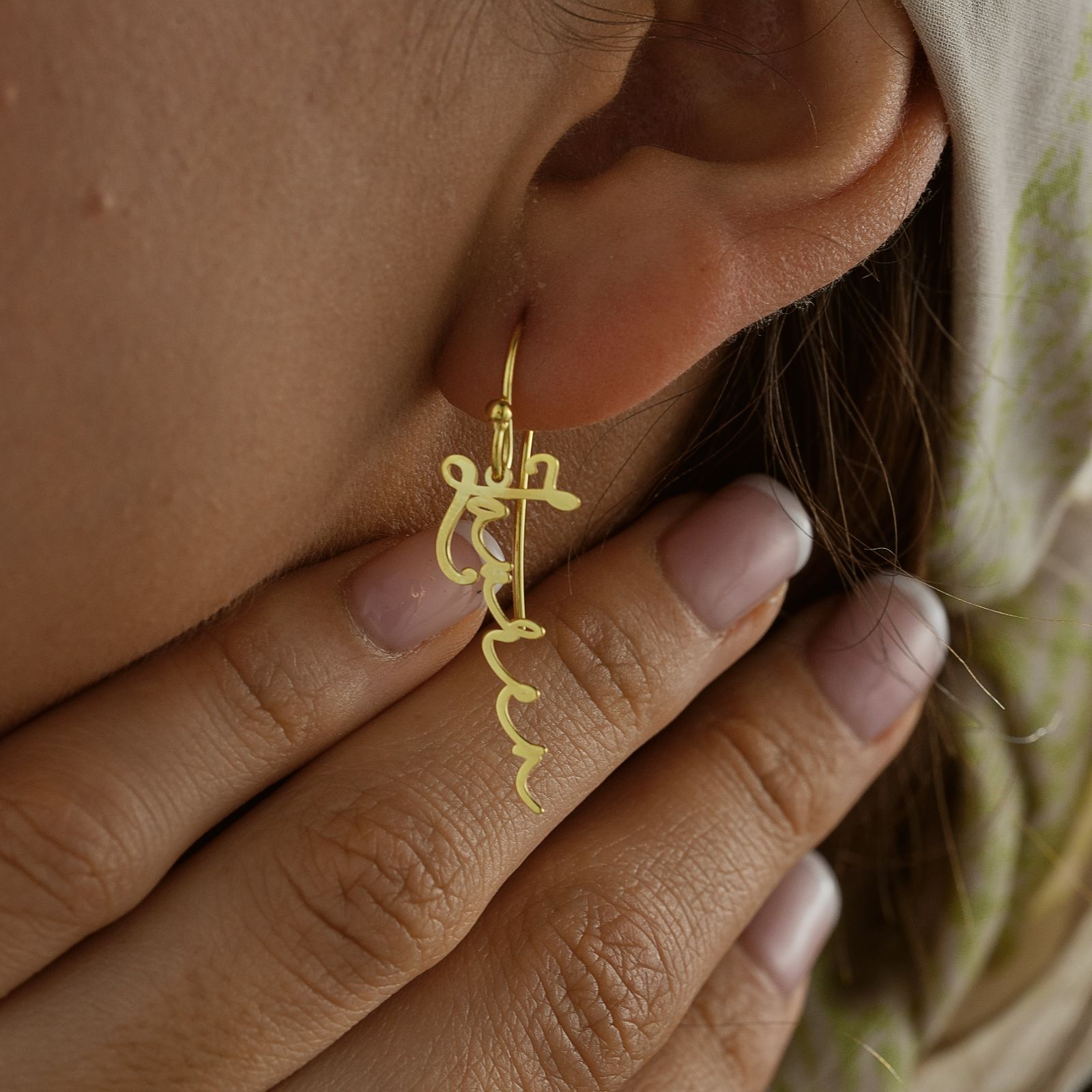 Personalized Name Earrings in gold worn by a model, showcasing elegant design and craftsmanship, perfect for any occasion.