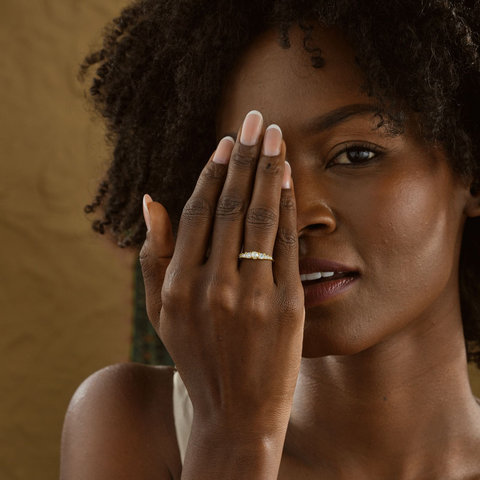 Close-up of a model showcasing a Vintage Cross Signet Ring with pearl and CZ diamonds.