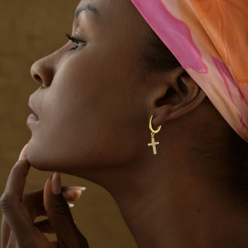 Elegant Diamond Cross Earring worn by a woman, showcasing the intricate design and shine.
