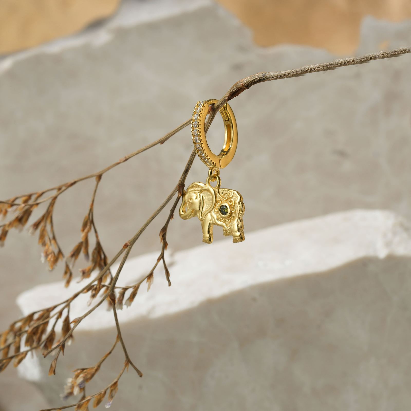 Elephant Hoop Earrings Sterling Silver hanging on a branch surrounded by natural elements.