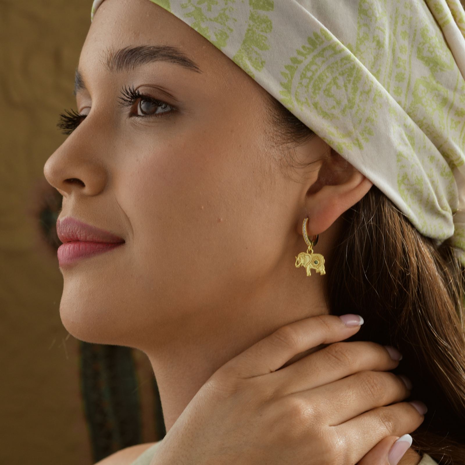 Model showcasing Elephant Hoop Earrings Sterling Silver, highlighting a detailed elephant design.