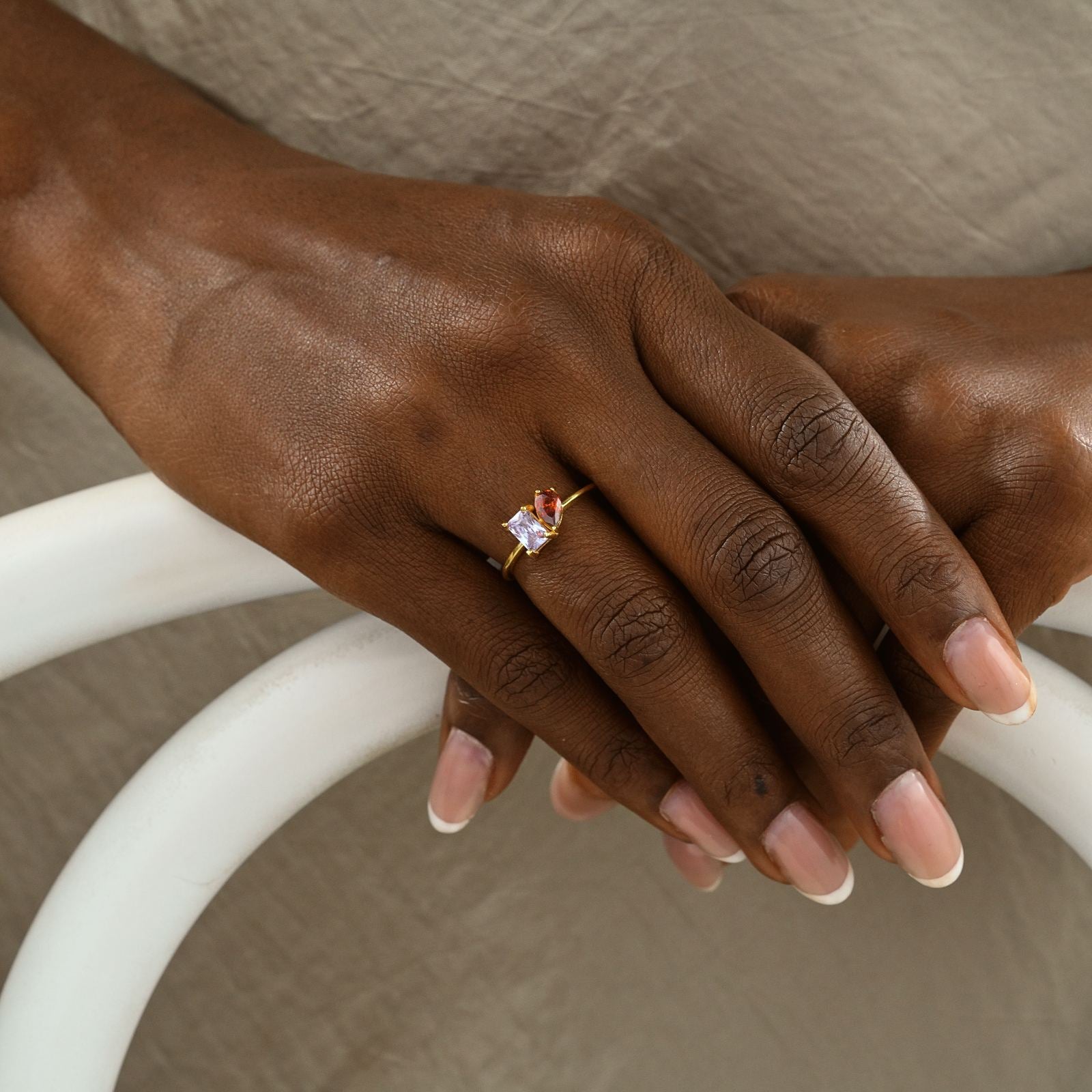 Oval & Emerald Cut Birthstone Ring worn on a model's hand showcasing high-quality materials and elegant design.
