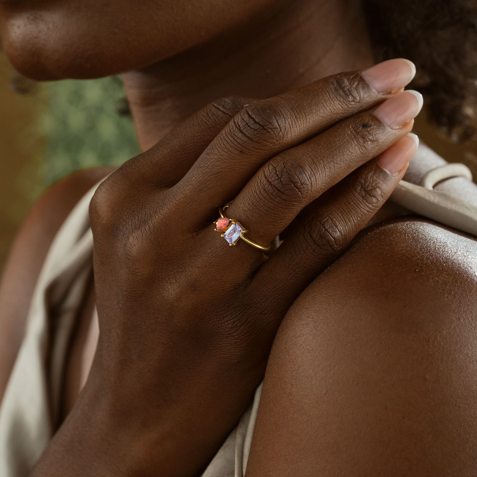 Woman wearing an Oval & Emerald Cut Birthstone Ring on her hand, showcasing its elegant design.