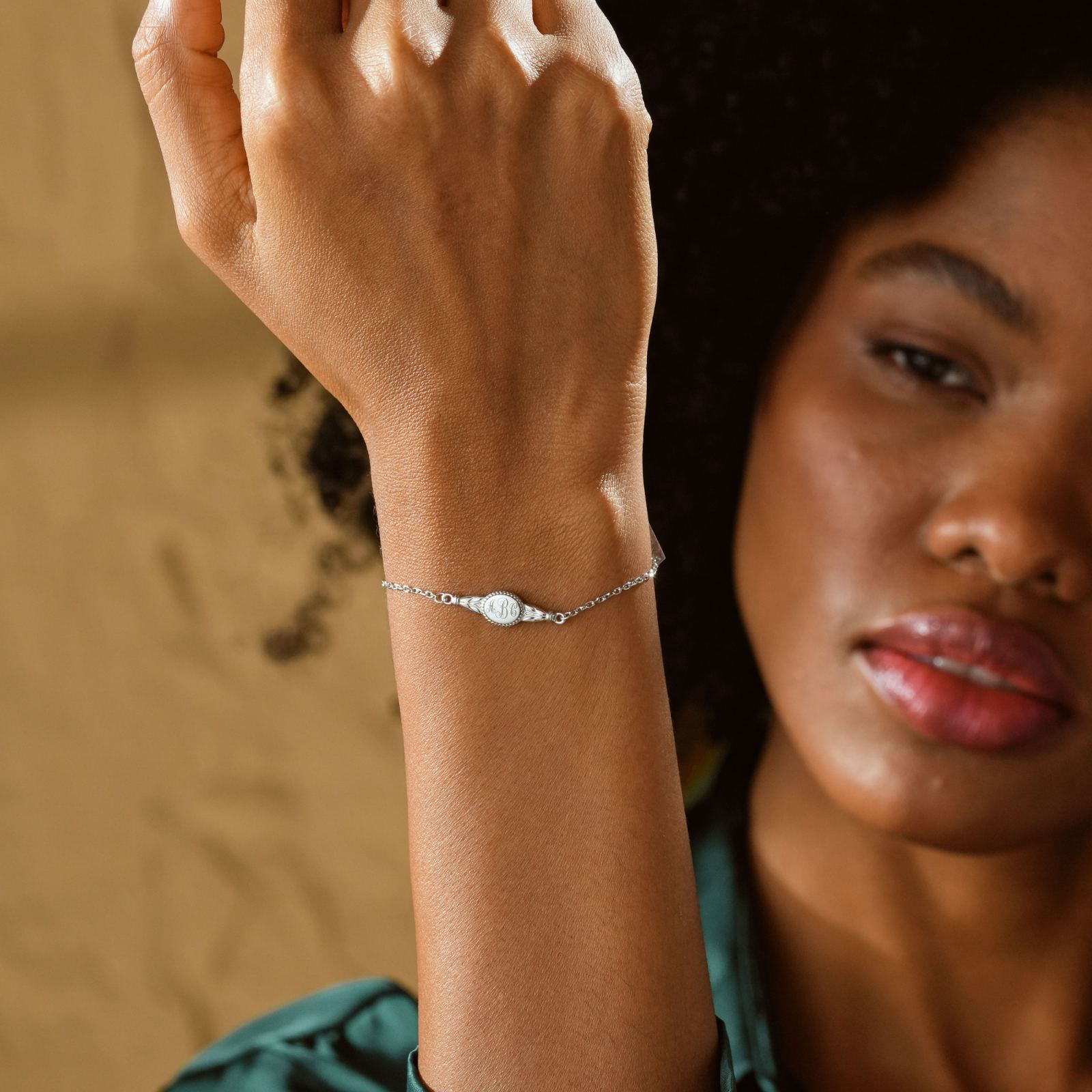 Engraved Oval Name Bracelet shown worn on a woman's wrist, showcasing its elegant design in sterling silver.
