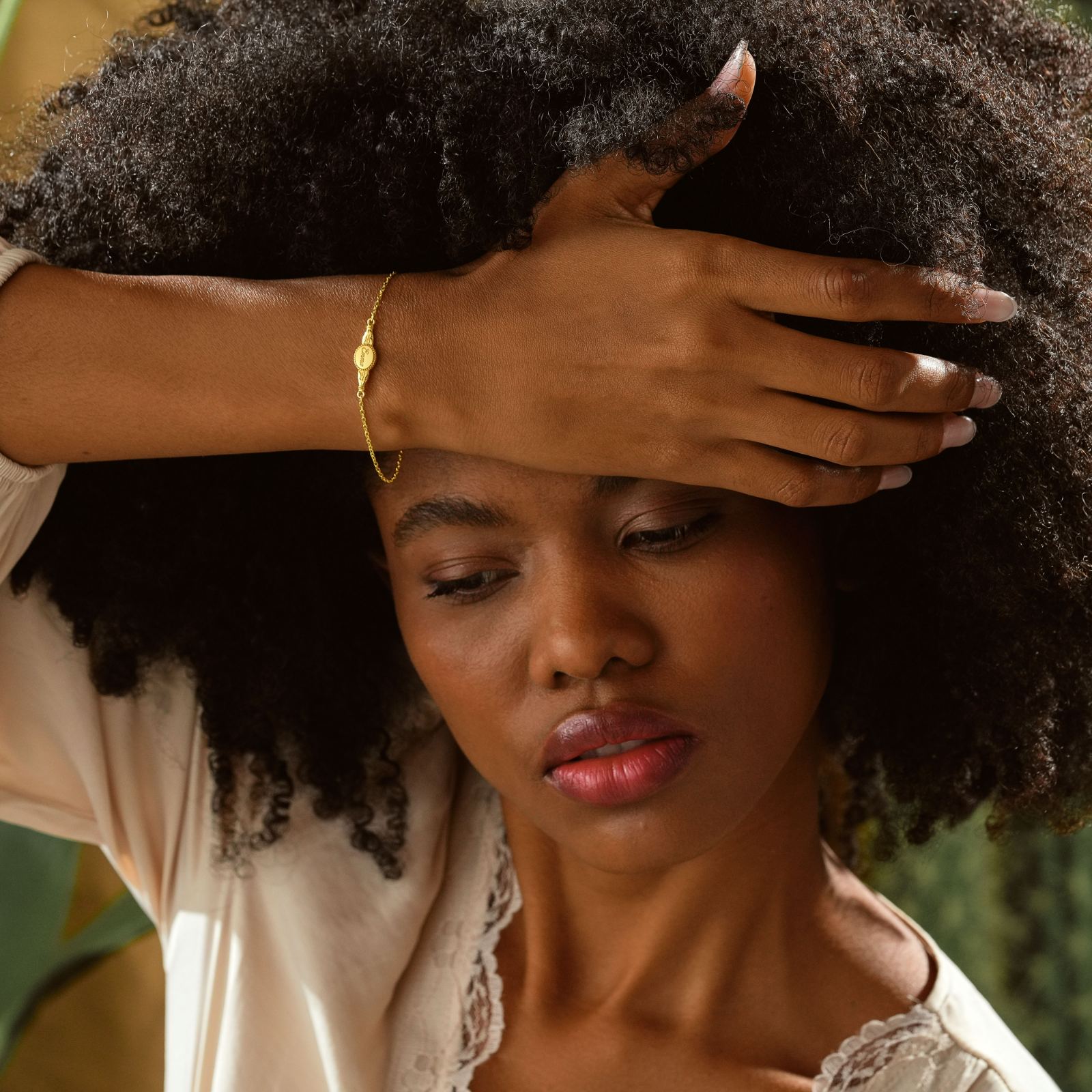 Engraved Oval Name Bracelet Sterling Silver worn on a model with curly hair, highlighting the elegant design.