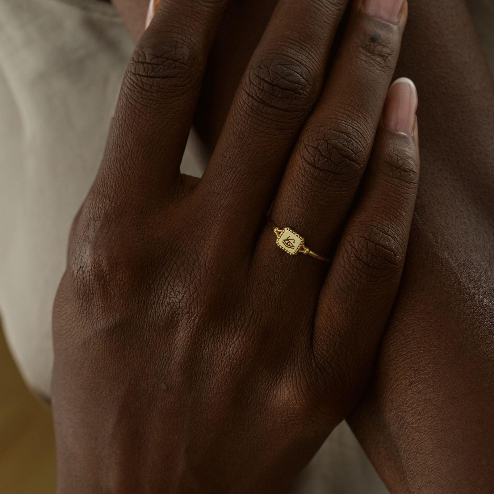 Hand wearing an Eye of Ra Signet Ring in gold vermeil, showcasing elegant jewelry design.