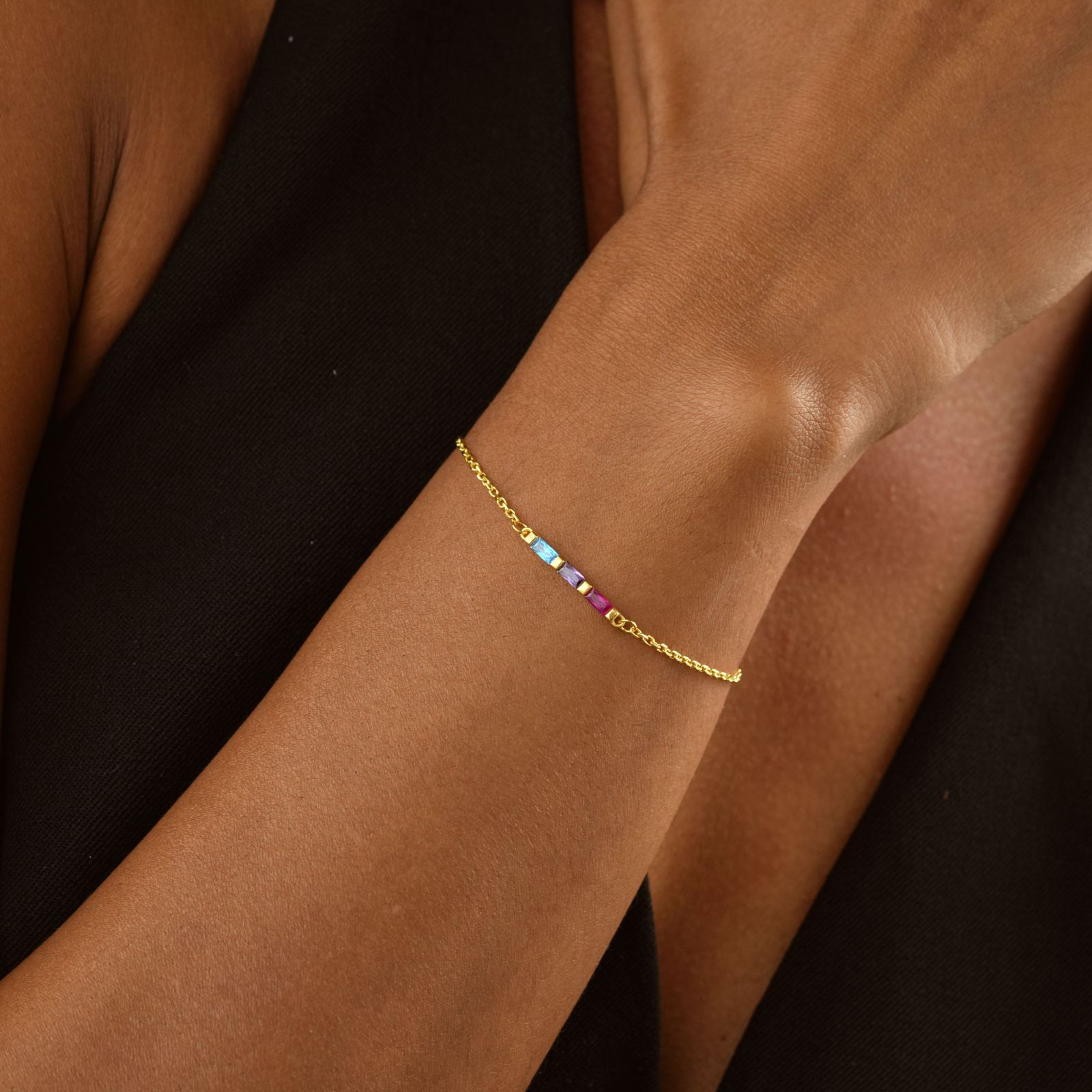 Elegant Gold Filled Birthstone Bracelet worn on a wrist with colorful gemstones and a delicate gold chain.