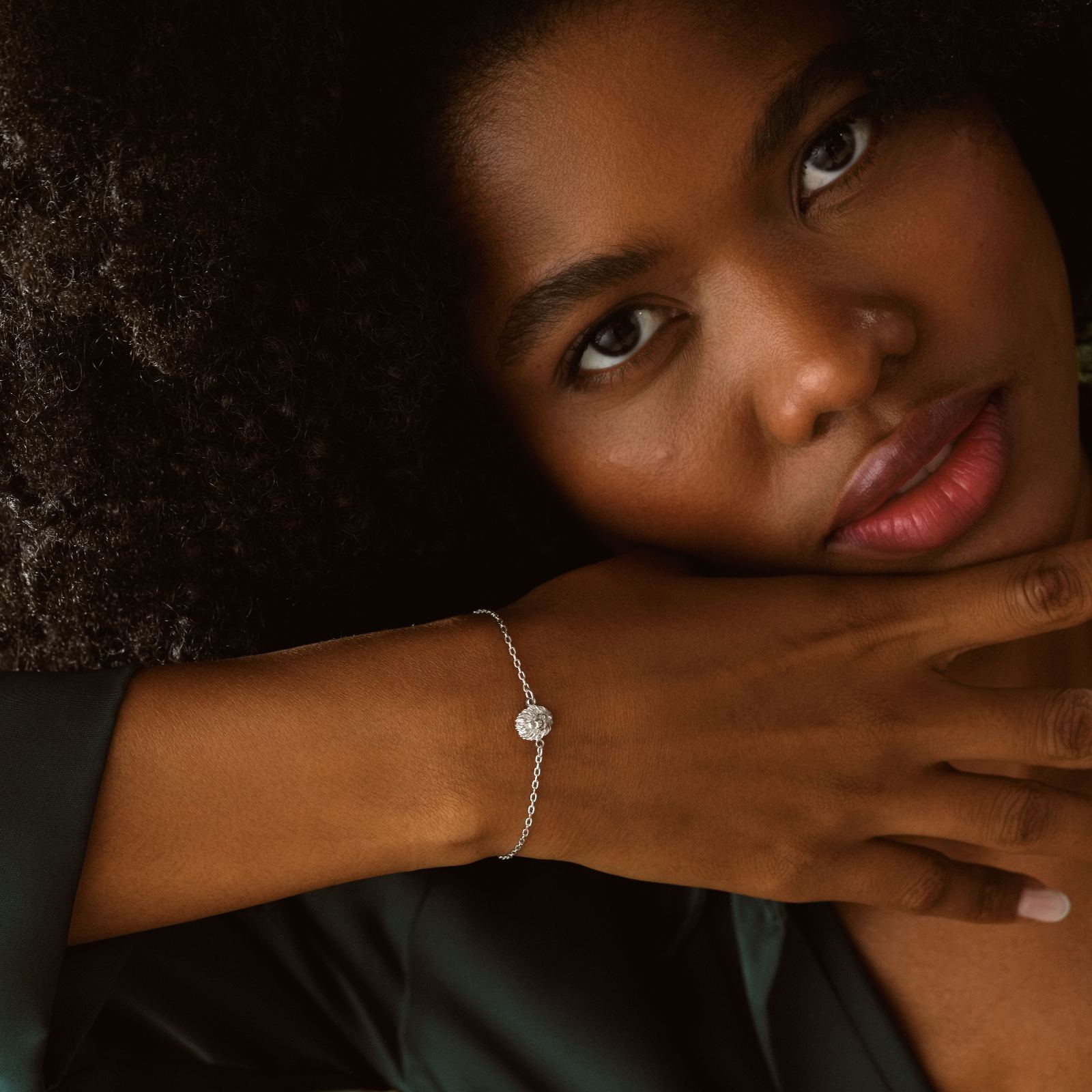 Lion Pendant Bracelet Minimalist worn by a woman with curly hair, showcasing its elegant design and craftsmanship.