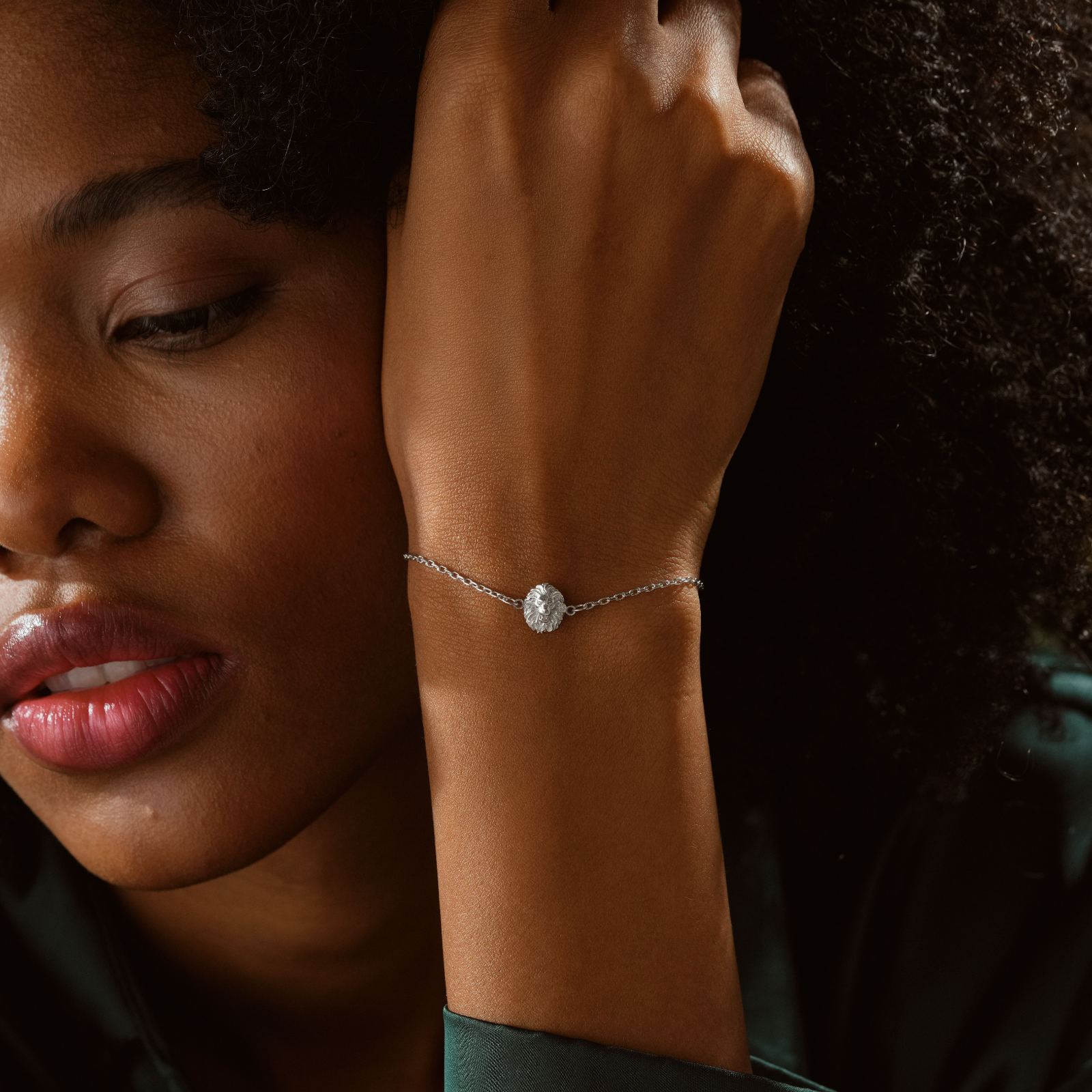 Lion Pendant Bracelet Minimalist worn on a woman's wrist, showcasing the intricate design and shine of the sterling silver.