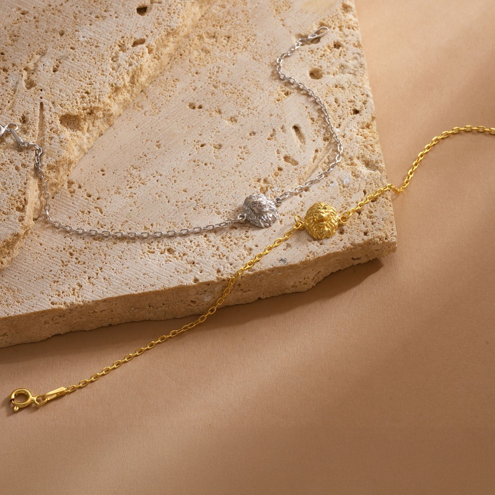 Lion Pendant Bracelet Minimalist in silver and gold on a textured surface, showcasing a luxurious design.