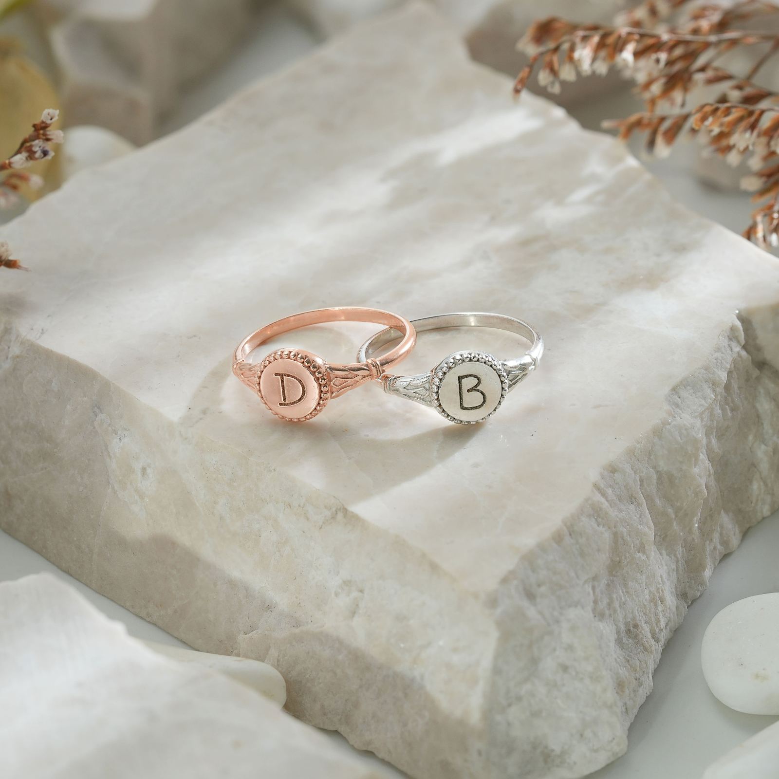 Personalized Initial Signet Letter Ring in rose gold and silver on a stone surface
