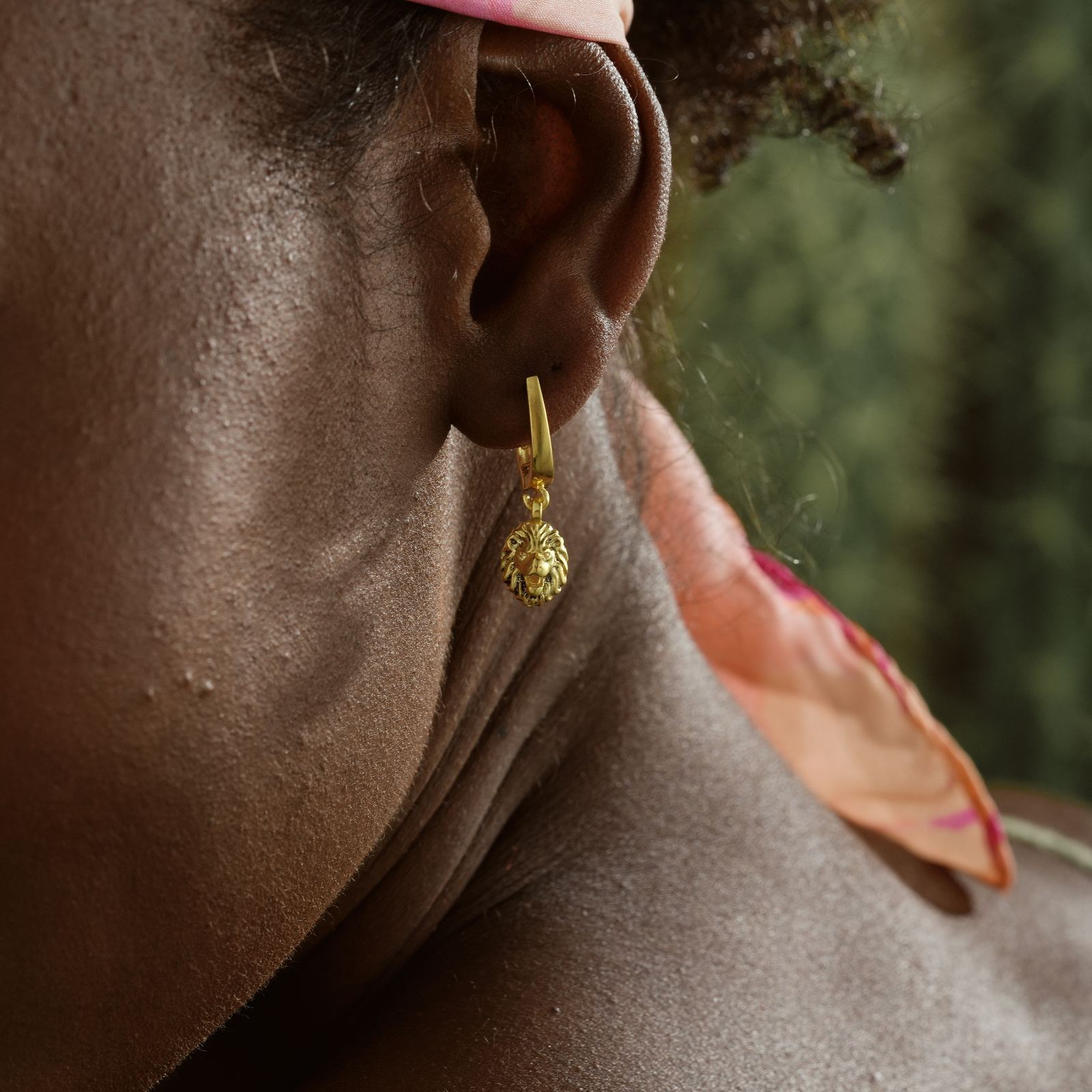Stylish Lion Dangle Huggie Hoop Earring worn on model's ear showcasing high-quality design and vibrant gold tone.