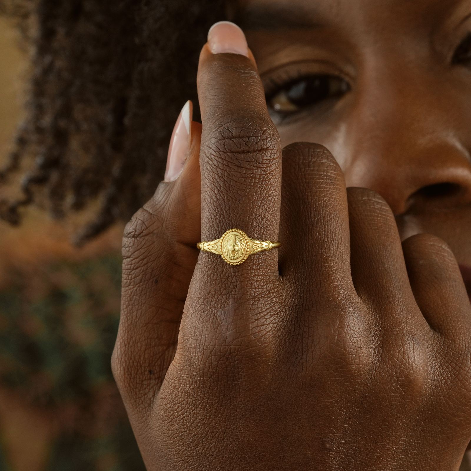 Close-up of a person wearing a gold Lion Ring, showcasing intricate design and minimalist style.