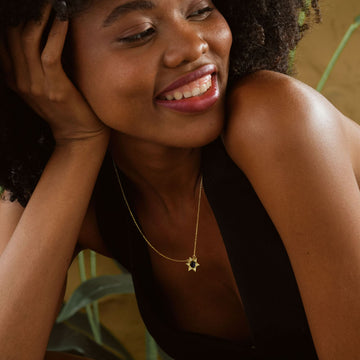 Woman wearing a Star of David Necklace Elegant Silver, smiling and showcasing the elegant design.