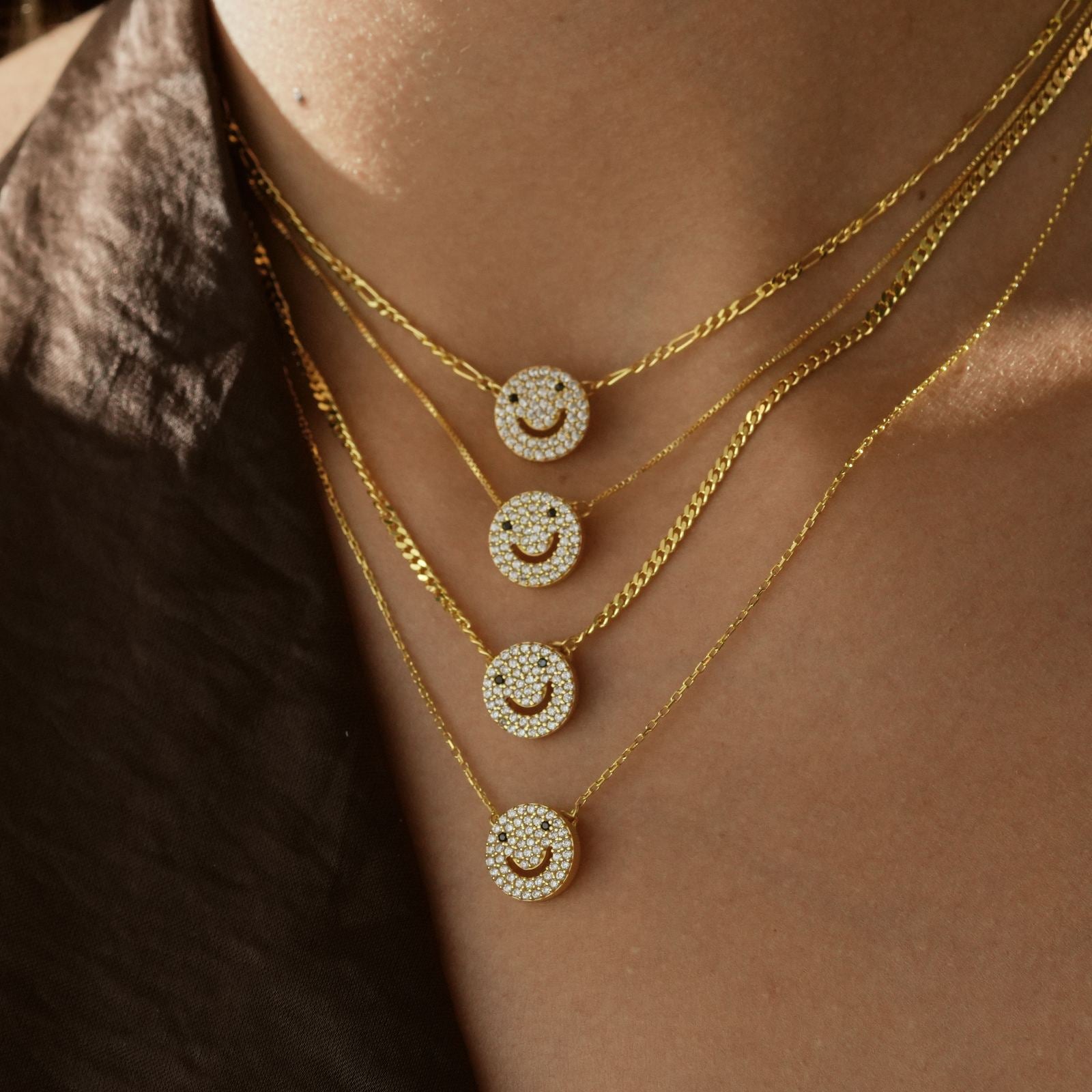 Charming Dainty Smiley Face Necklace displayed in layered gold chains with sparkling CZ diamonds.