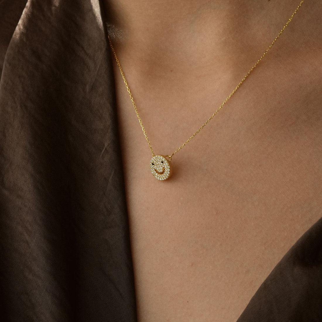 Charming Dainty Smiley Face Necklace worn by a model showcasing its gold finish and sparkling CZ diamond detail.