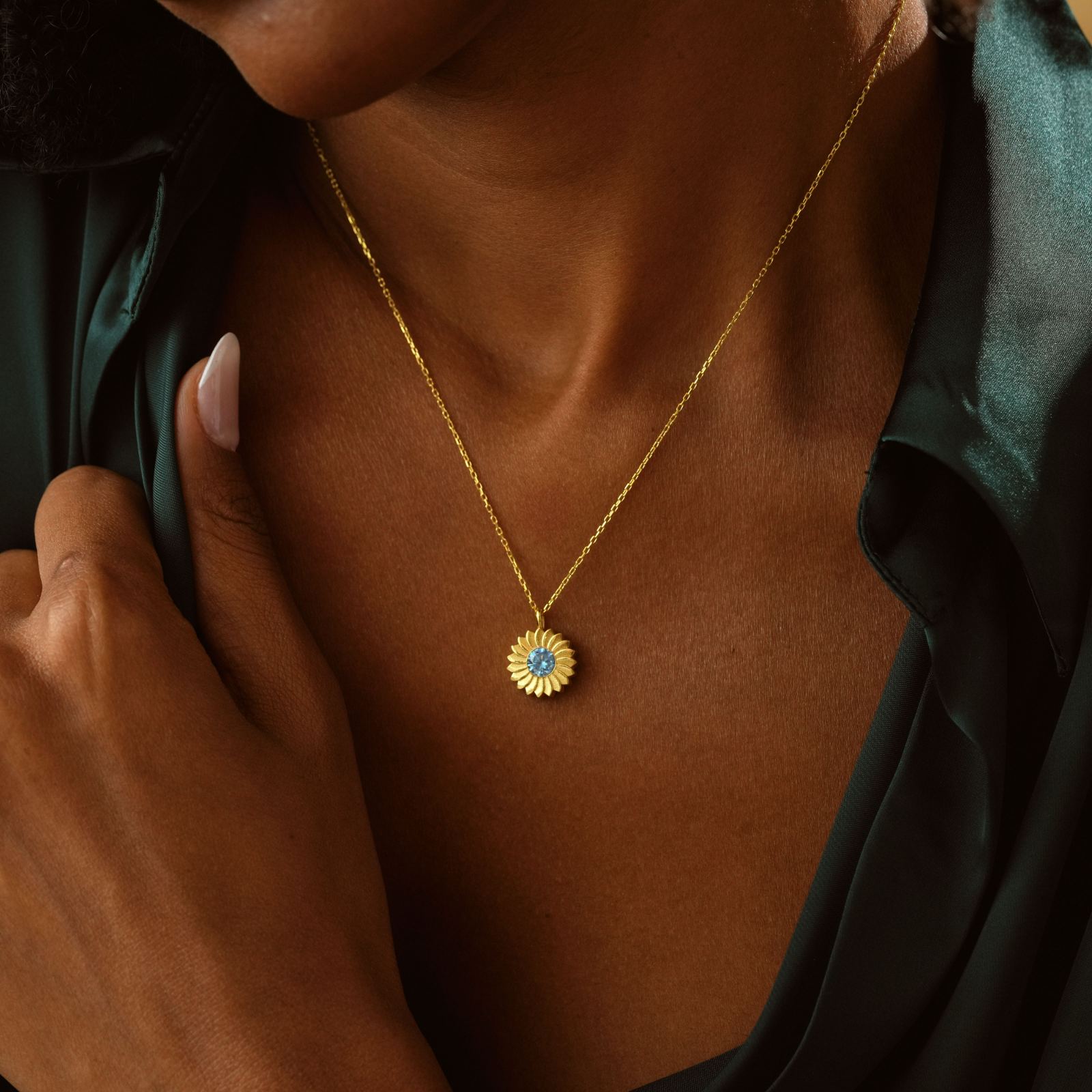 Charming Sunflower Birthstone Necklace worn by a woman, featuring a blue birthstone and gold finish.