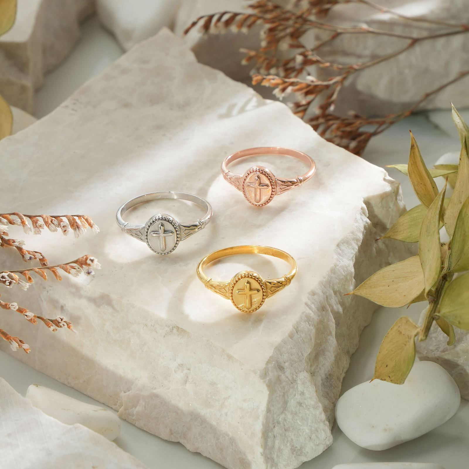 Vintage Cross Signet Ring collection featuring silver, gold, and rose gold styles on marble surface.