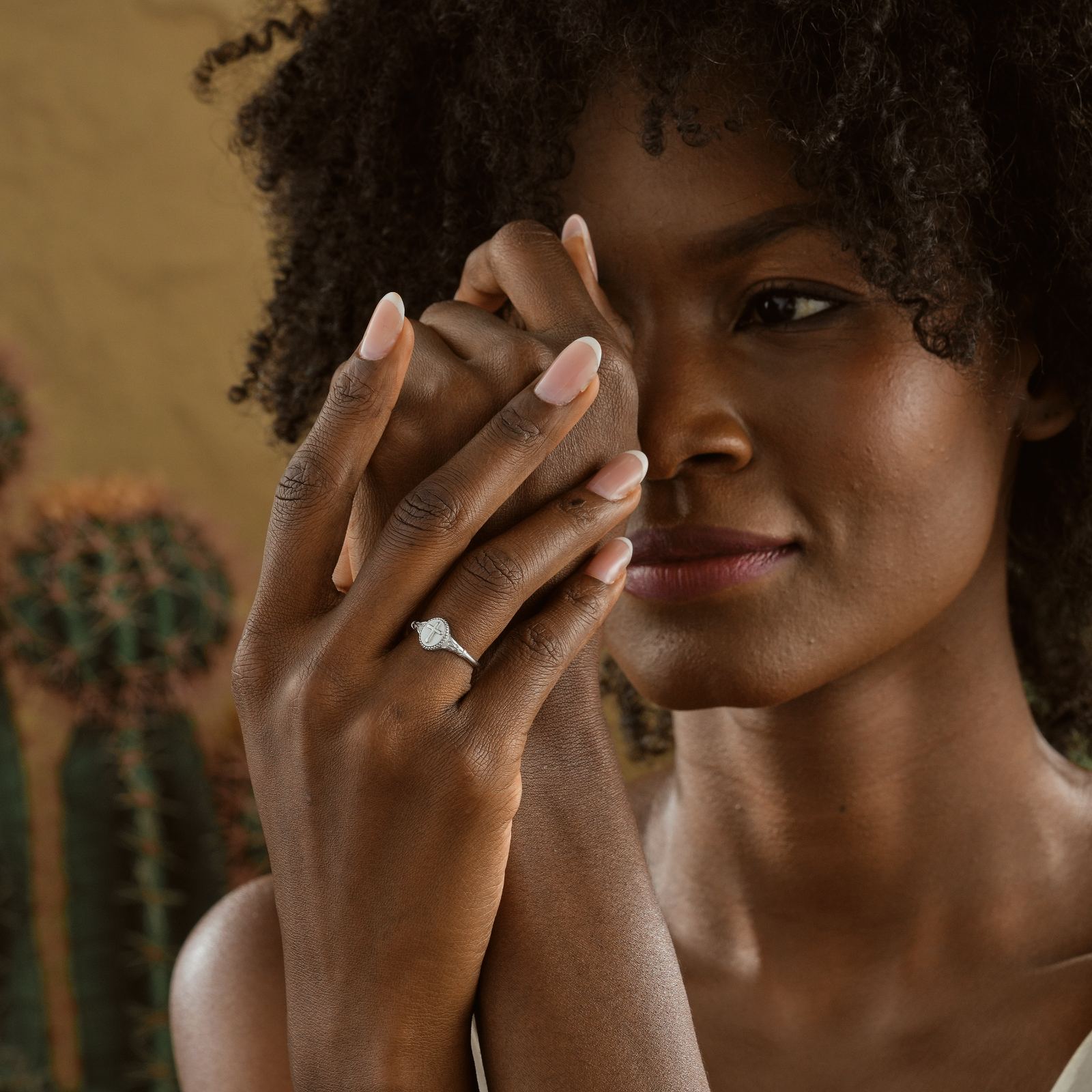 Close-up of a woman showcasing a Vintage Cross Signet Ring, highlighting its unique design and elegance.
